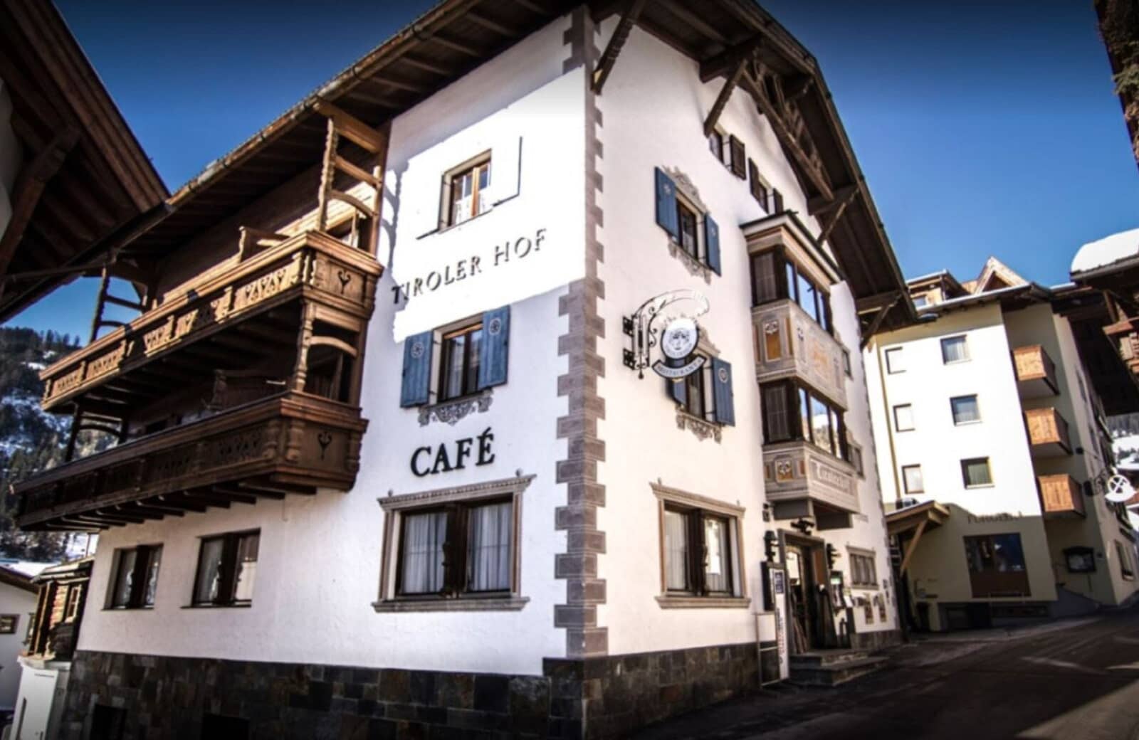 Chalet exterior with ground-floor cafe and private wooden balconies