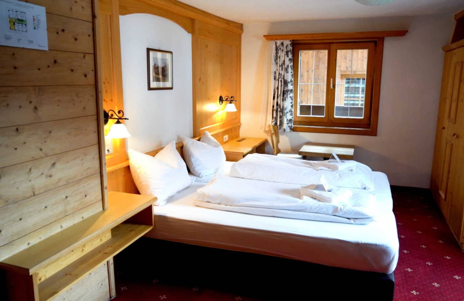 Guest bedroom with two twin mattresses and wood-paneled built-in desk
