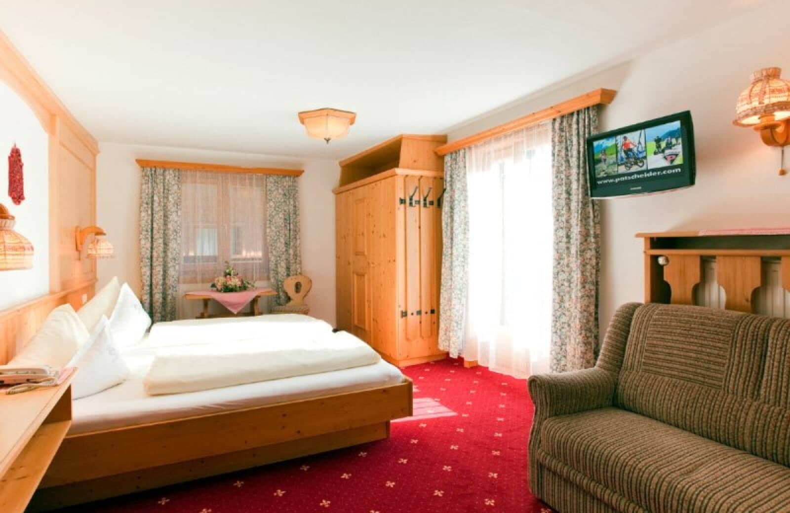 Guest bedroom with king bed, pine wardrobe, and seating area