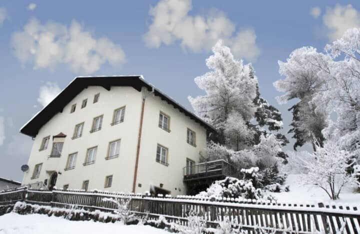 Chalet exterior with three levels and private side balcony in winter