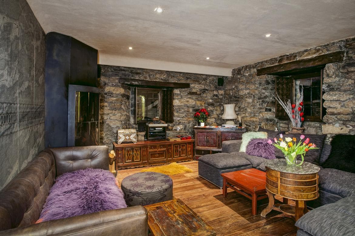 Living area with exposed stone walls and fireplace