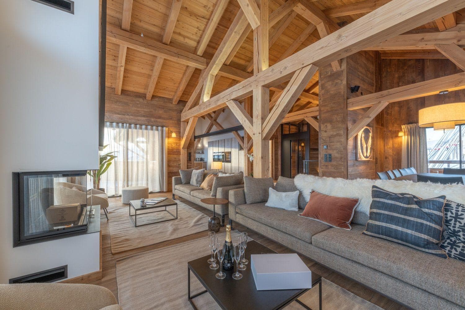 Open-plan living area with wood-burning fireplace and exposed timber beams