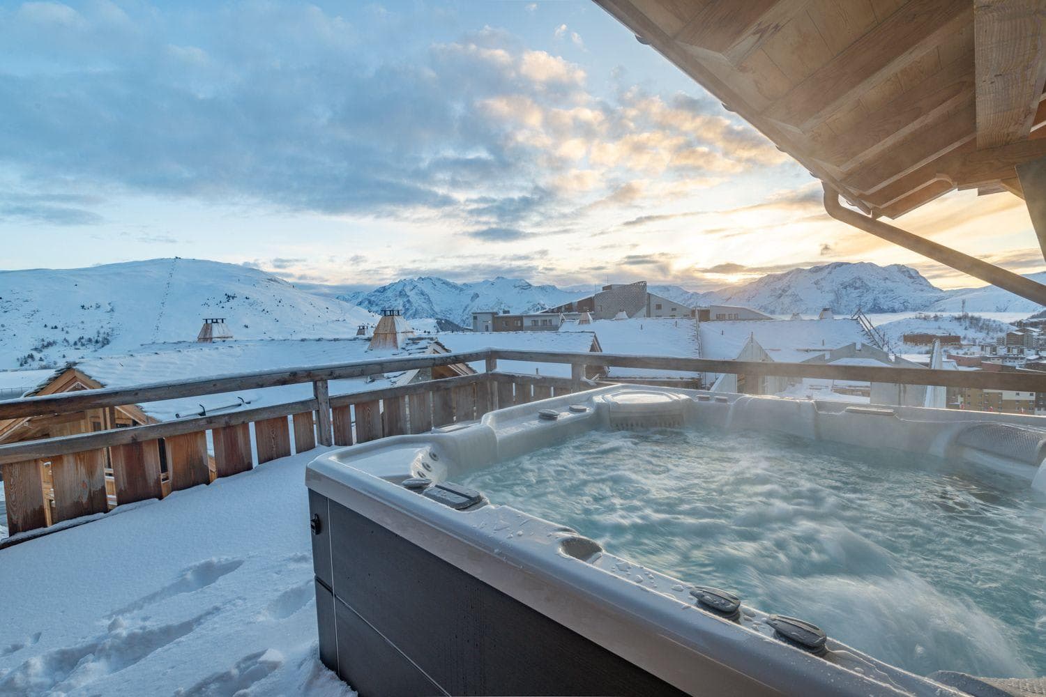 Private balcony hot tub with panoramic Alpine sunset views