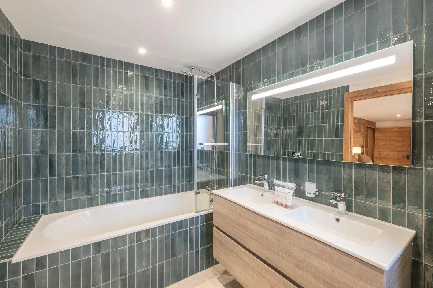 En-suite bathroom with a bath, double basins and rainfall shower