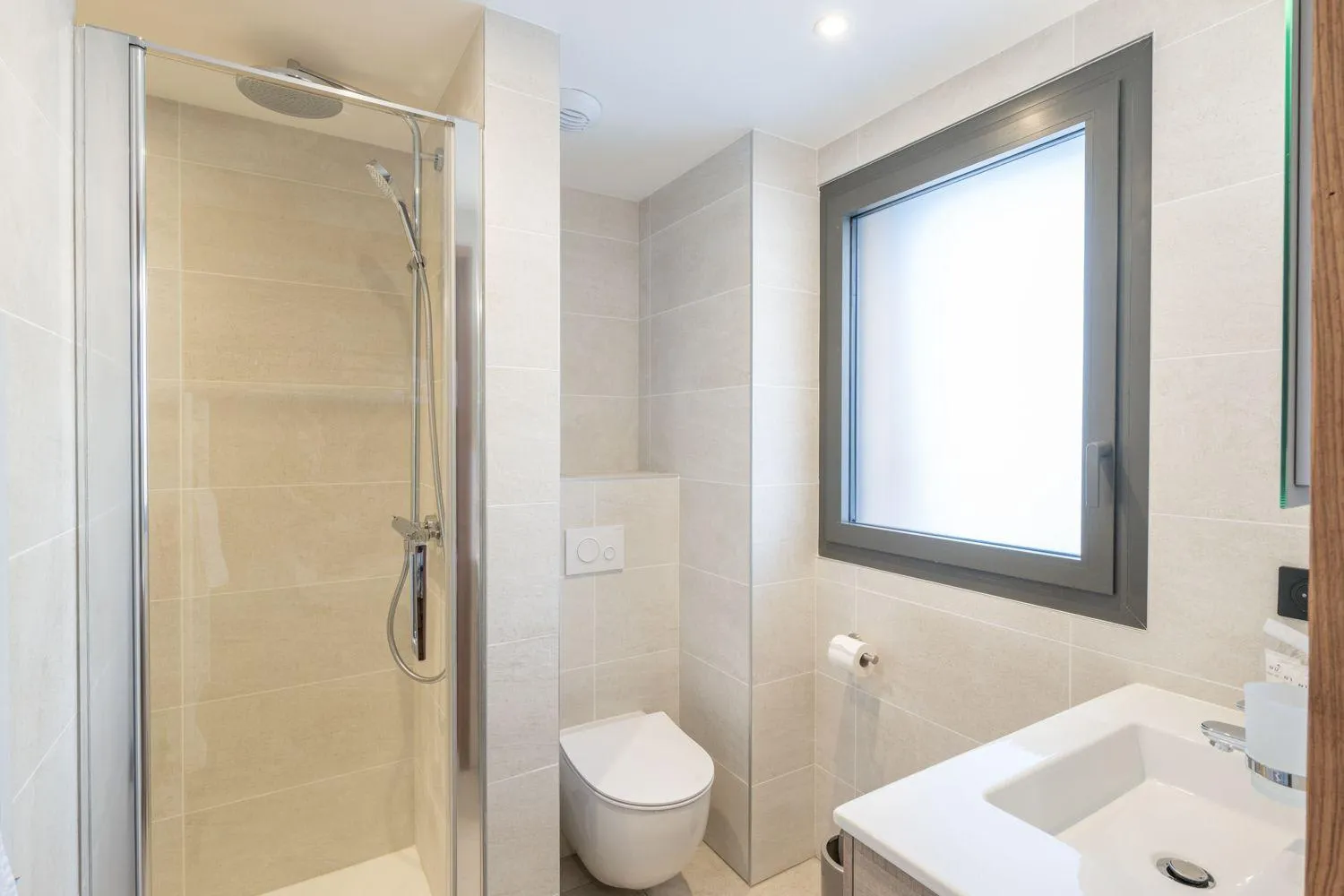 En-suite bathroom with a walk-in shower and frosted window