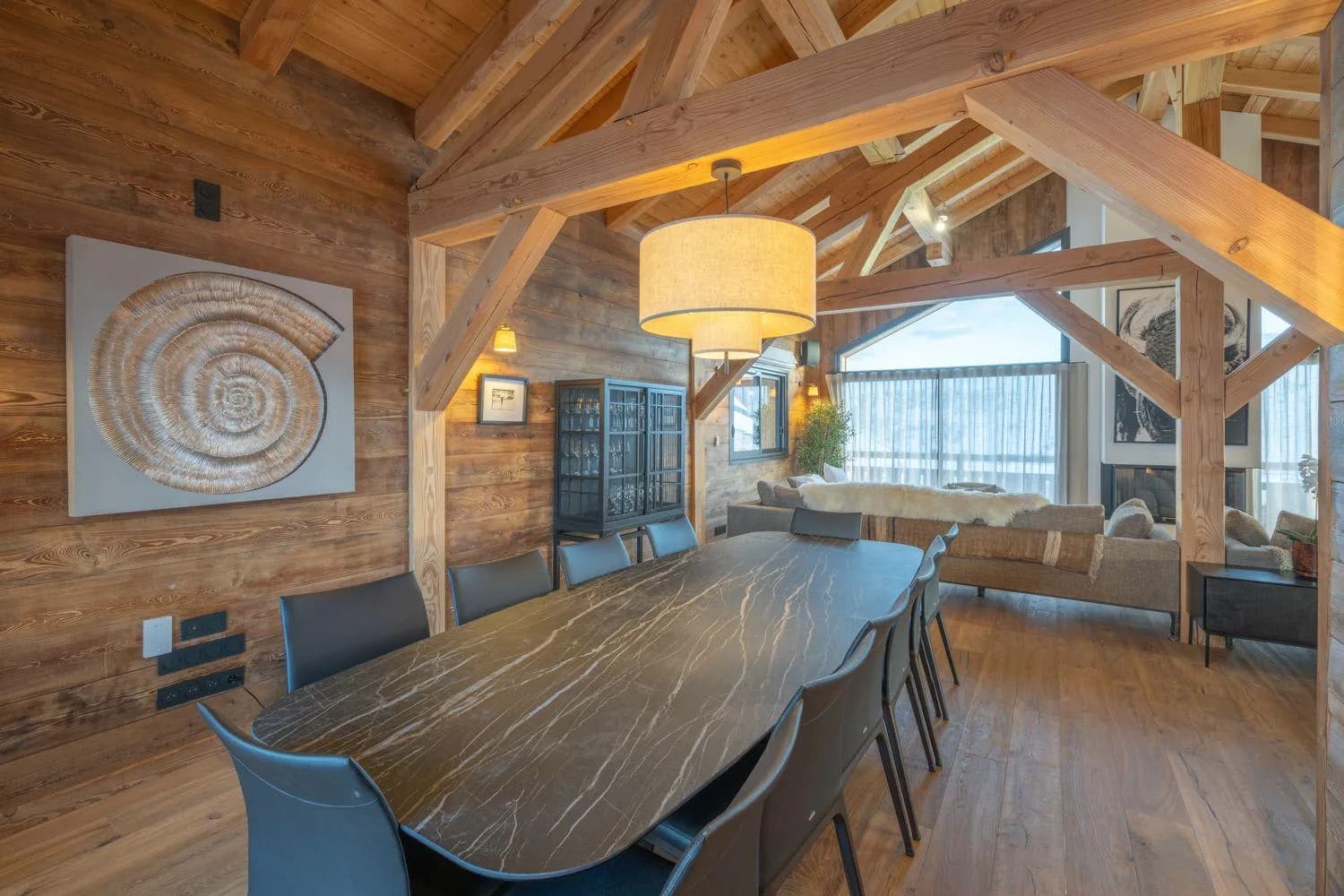 Dining area beneath a vaulted timber ceiling with mountain views