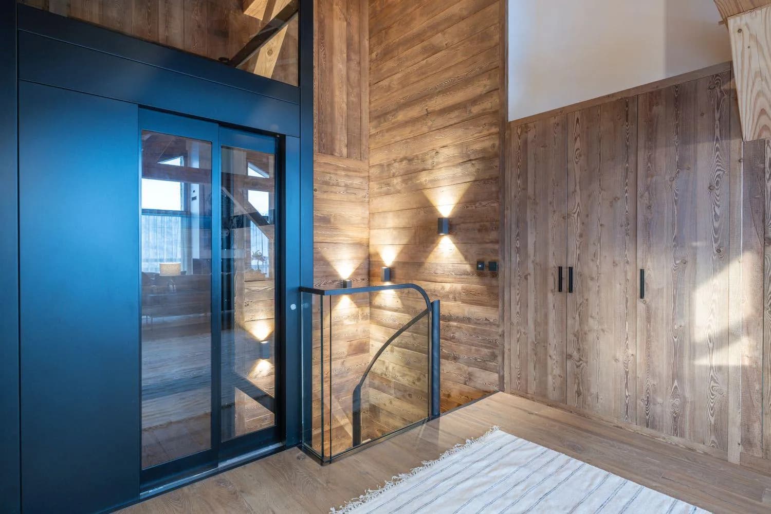 Upper landing with glass elevator access and built-in storage