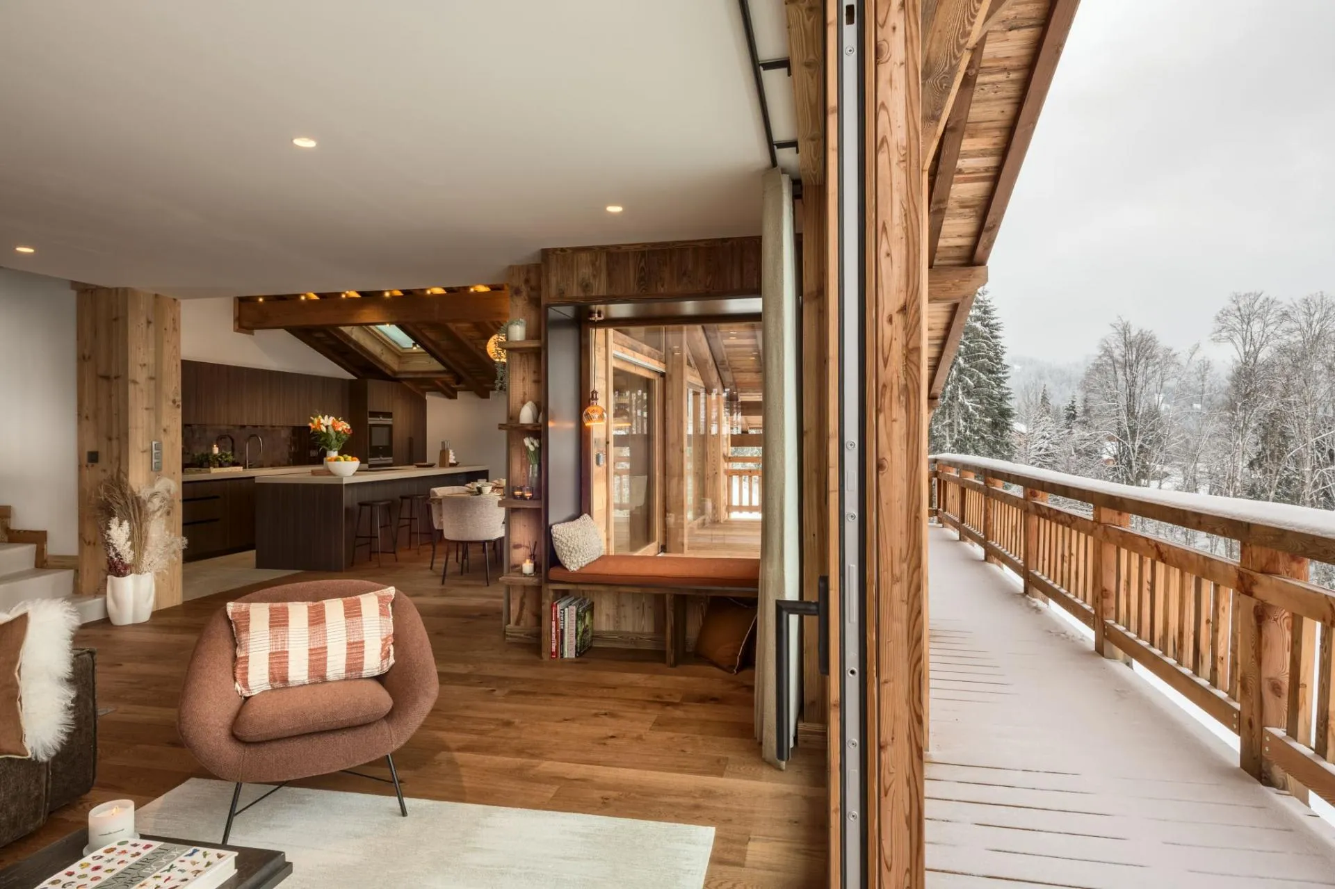 Open-plan living area with reading nook and snow-covered balcony access