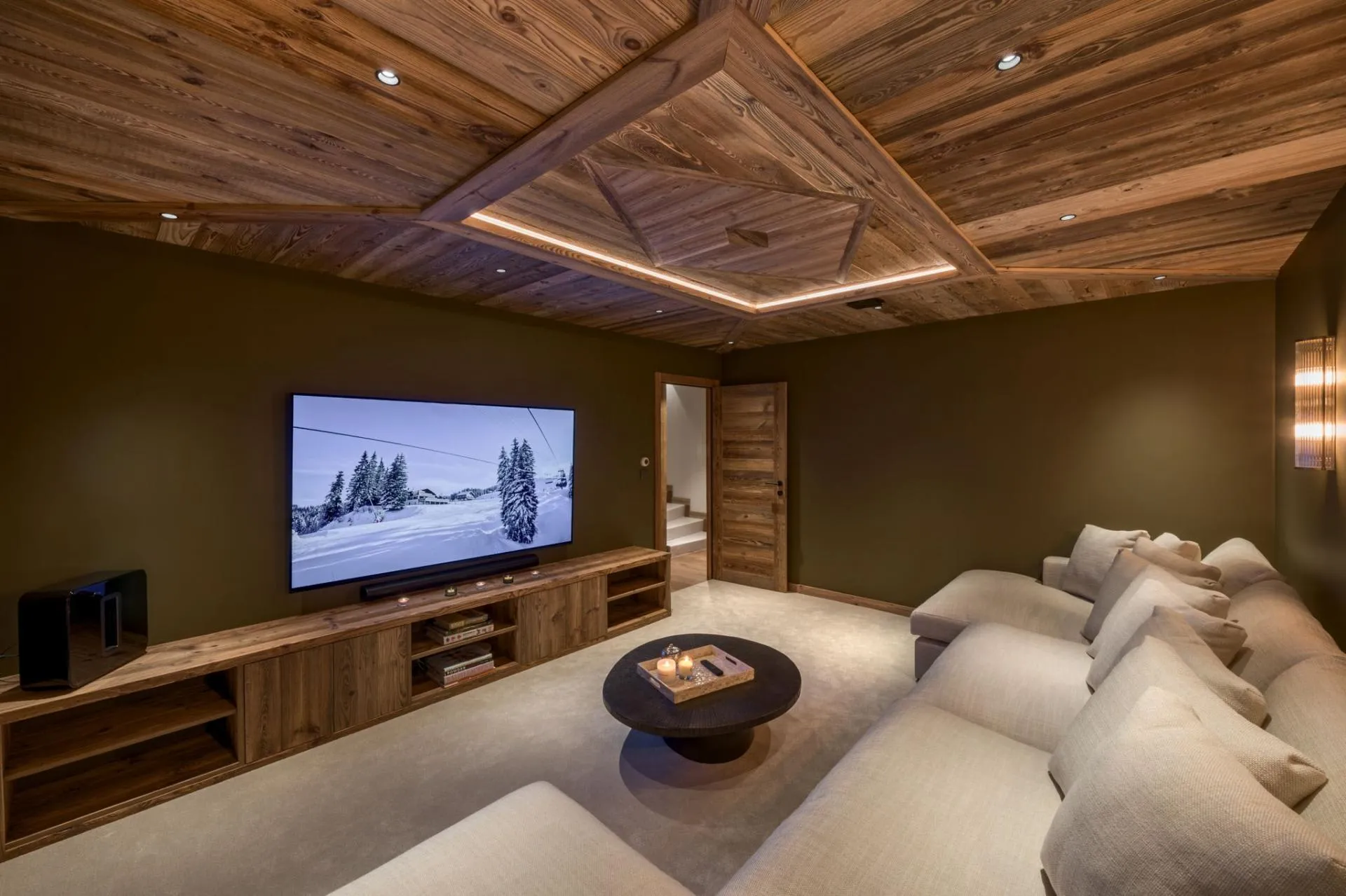 Home cinema with a large screen and timber-clad ceiling