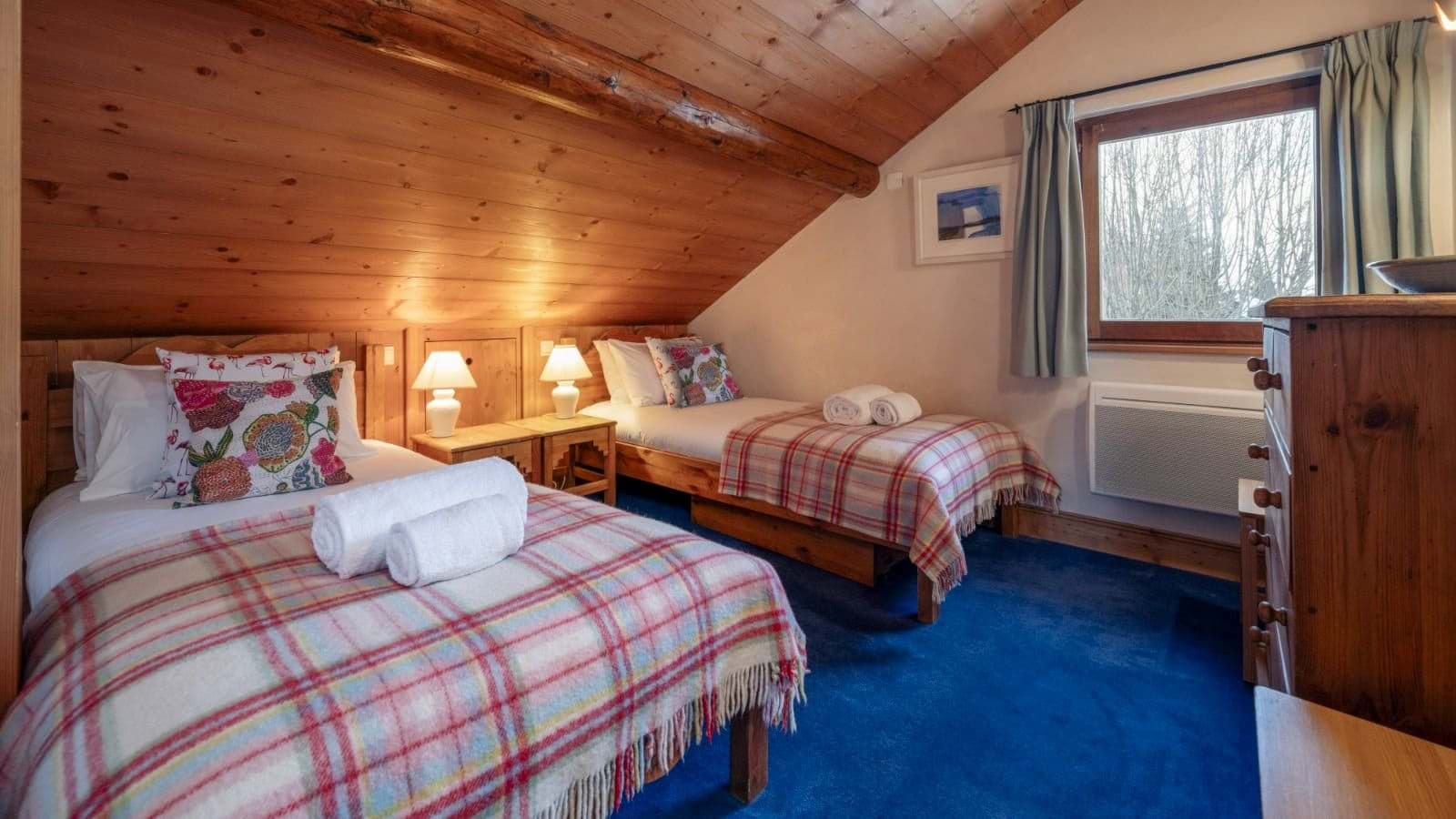 Guest bedroom with two twin beds and wood-paneled vaulted ceiling