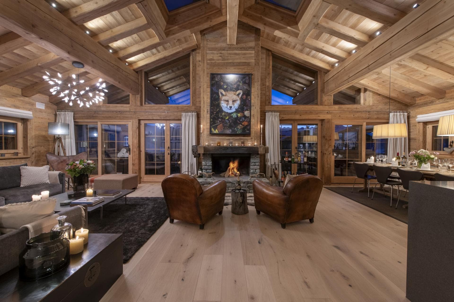 Open-plan living area with vaulted timber ceilings and wood-burning fireplace