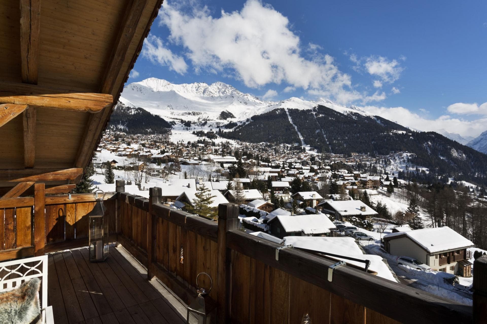Covered wooden balcony with views of village and snowy peaks