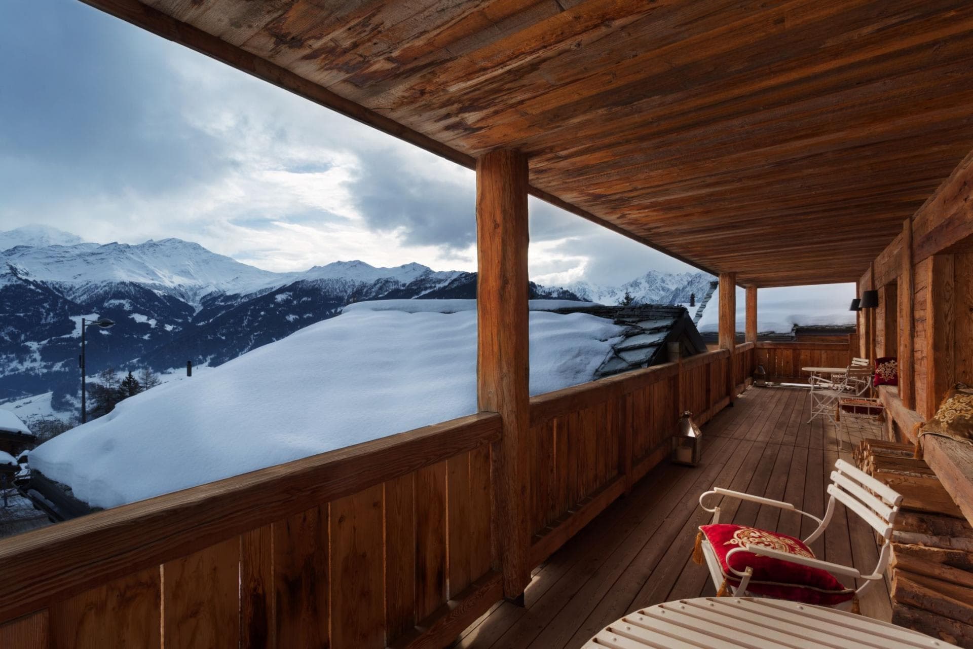 Covered timber balcony with seating and panoramic mountain views