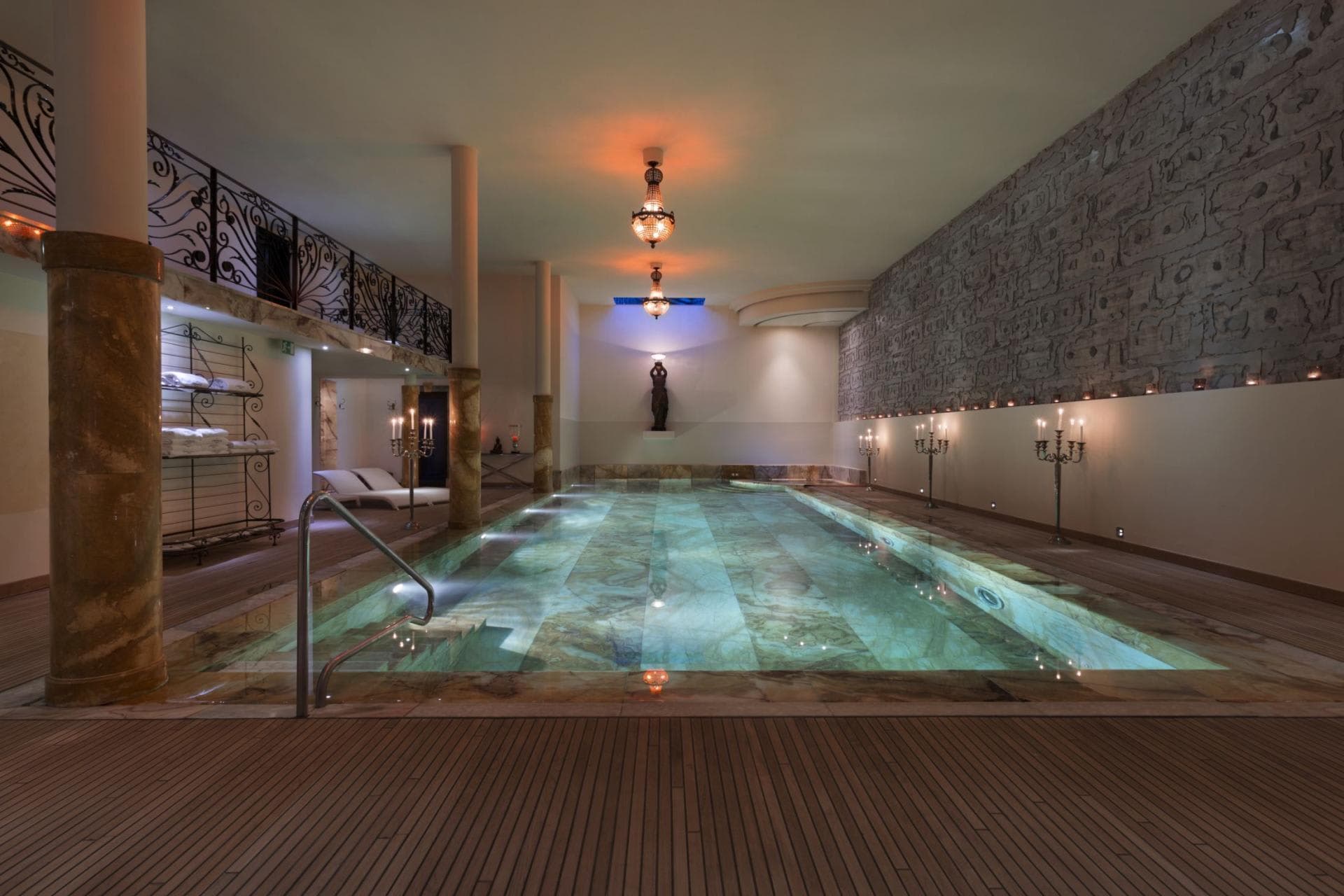 Indoor lap pool with marble tiling and hieroglyphic stone wall