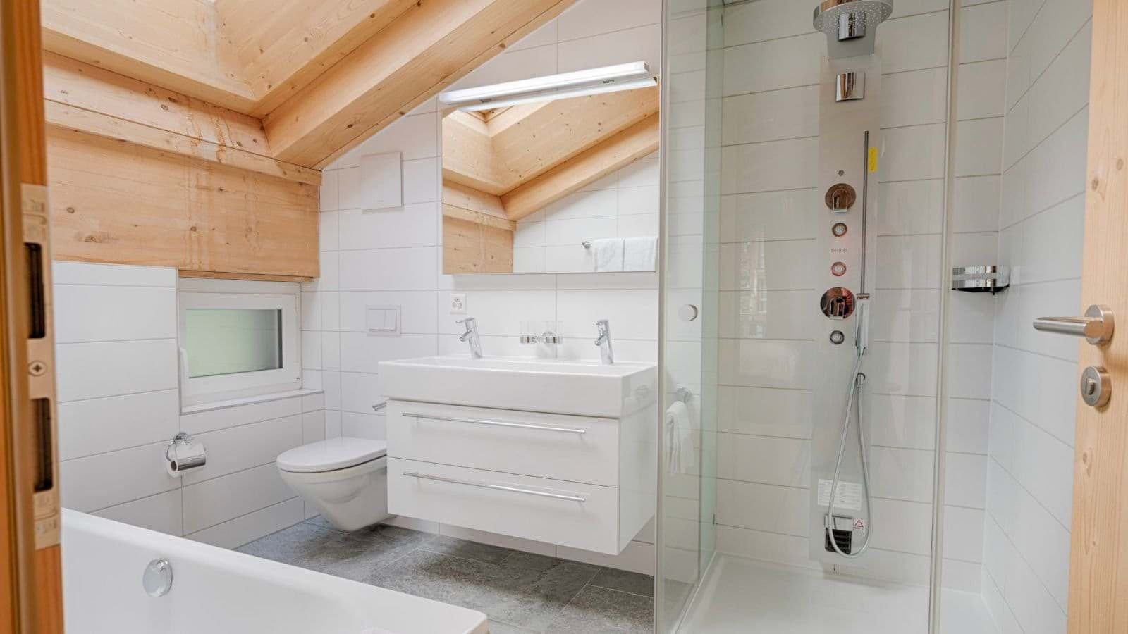 Bathroom with walk-in rainfall shower, soaking tub, and vaulted timber ceilings