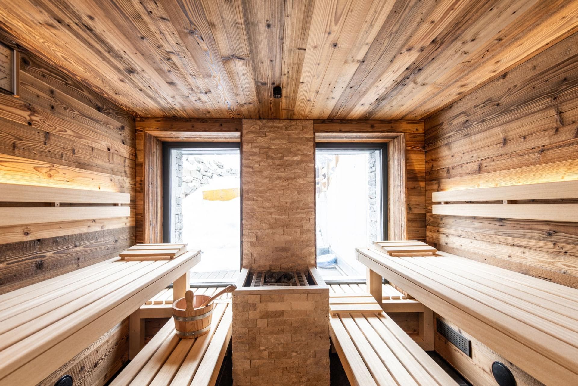 Wood sauna with central stone heater and snow views