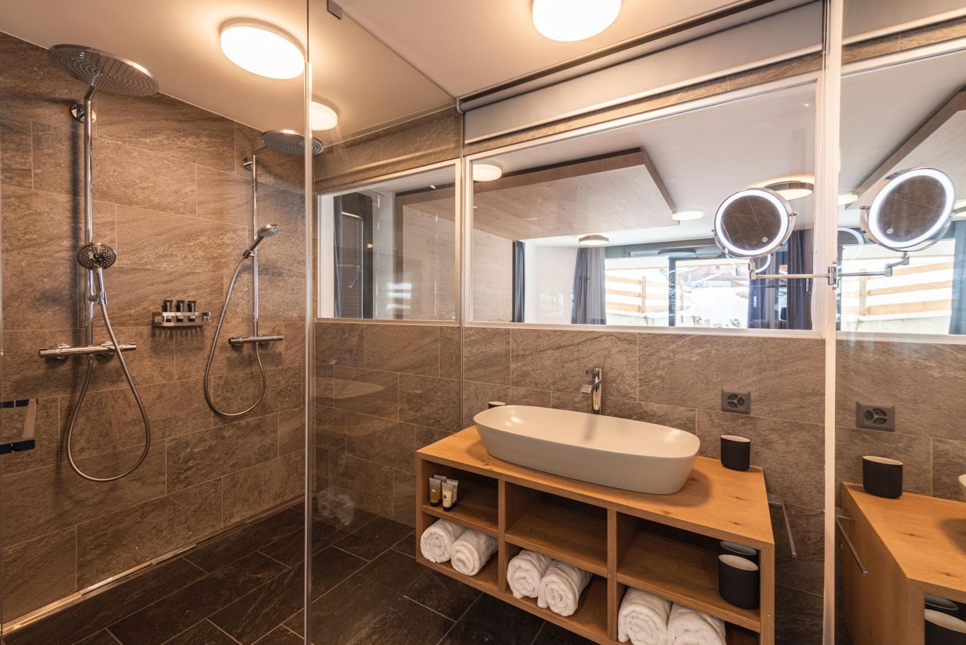 Bathroom with dual-head walk-in shower and lighted vanity mirrors