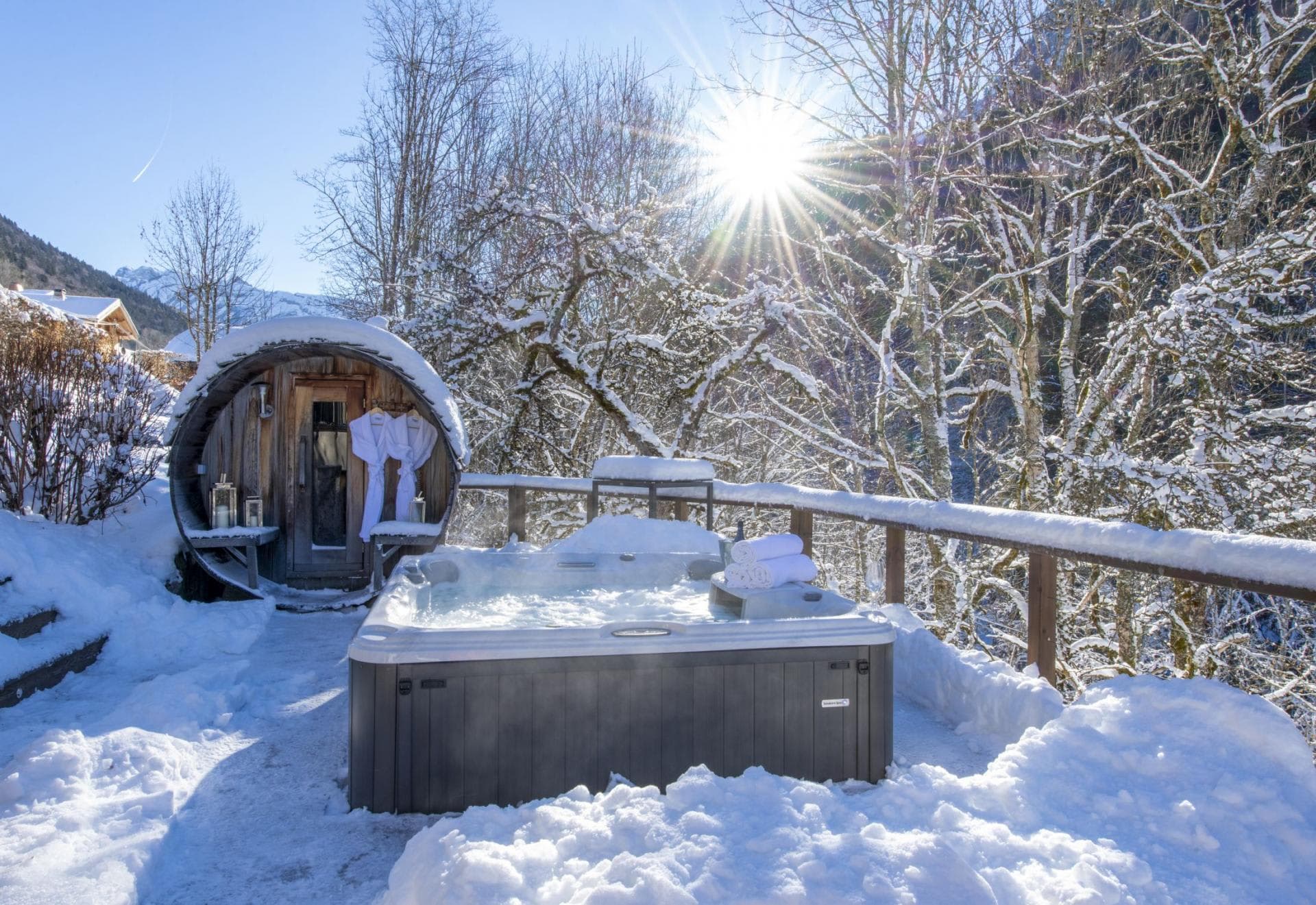 Outdoor hot tub and wood-fired barrel sauna with mountain views