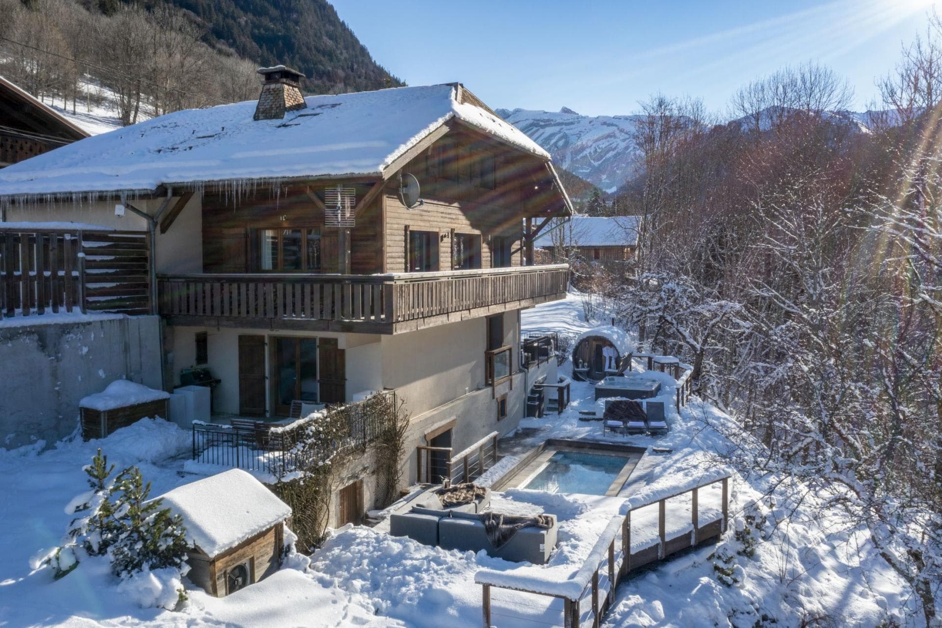 Chalet exterior with heated pool, hot tub, and barrel sauna