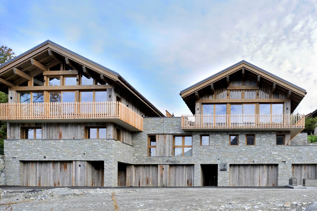 Chalet exterior with stone facade, private balconies, and integrated garage parking