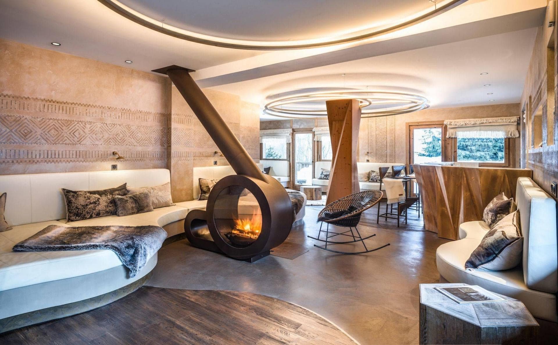 Lounge area featuring circular wood-burning fireplace and carved plaster walls