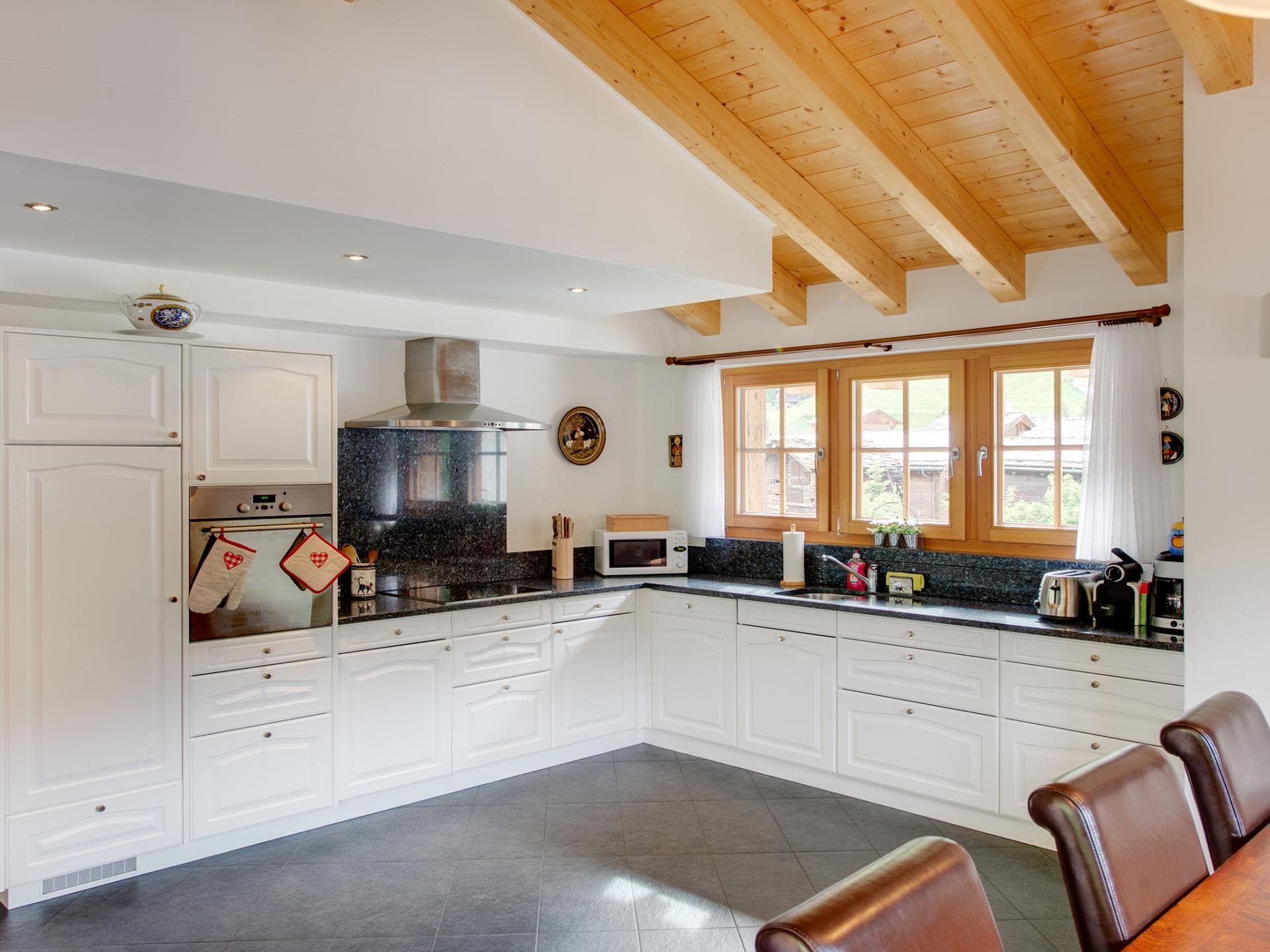 Kitchen with granite countertops and exposed wood-beamed ceiling