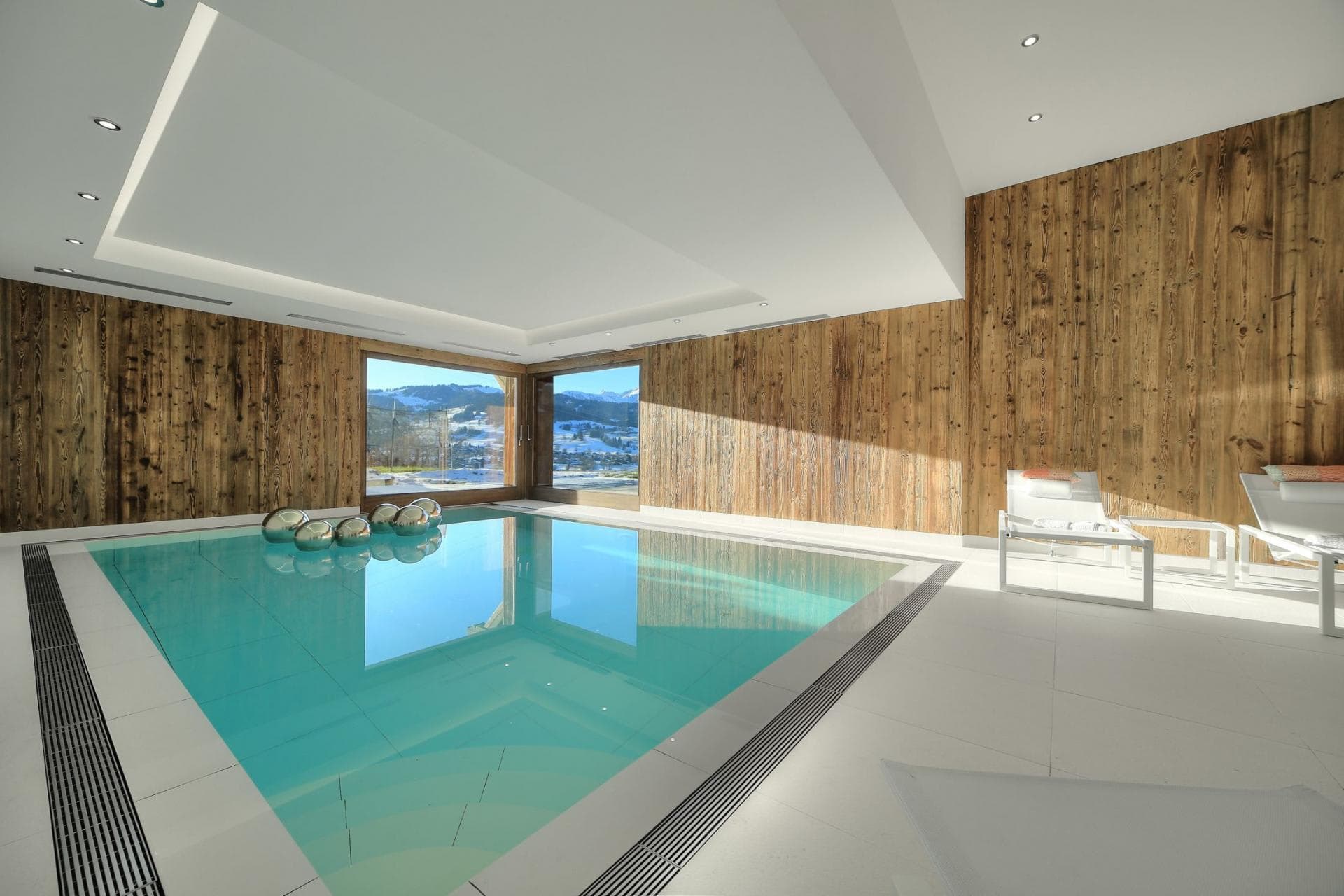 Indoor pool with wood-paneled walls and snowy mountain views