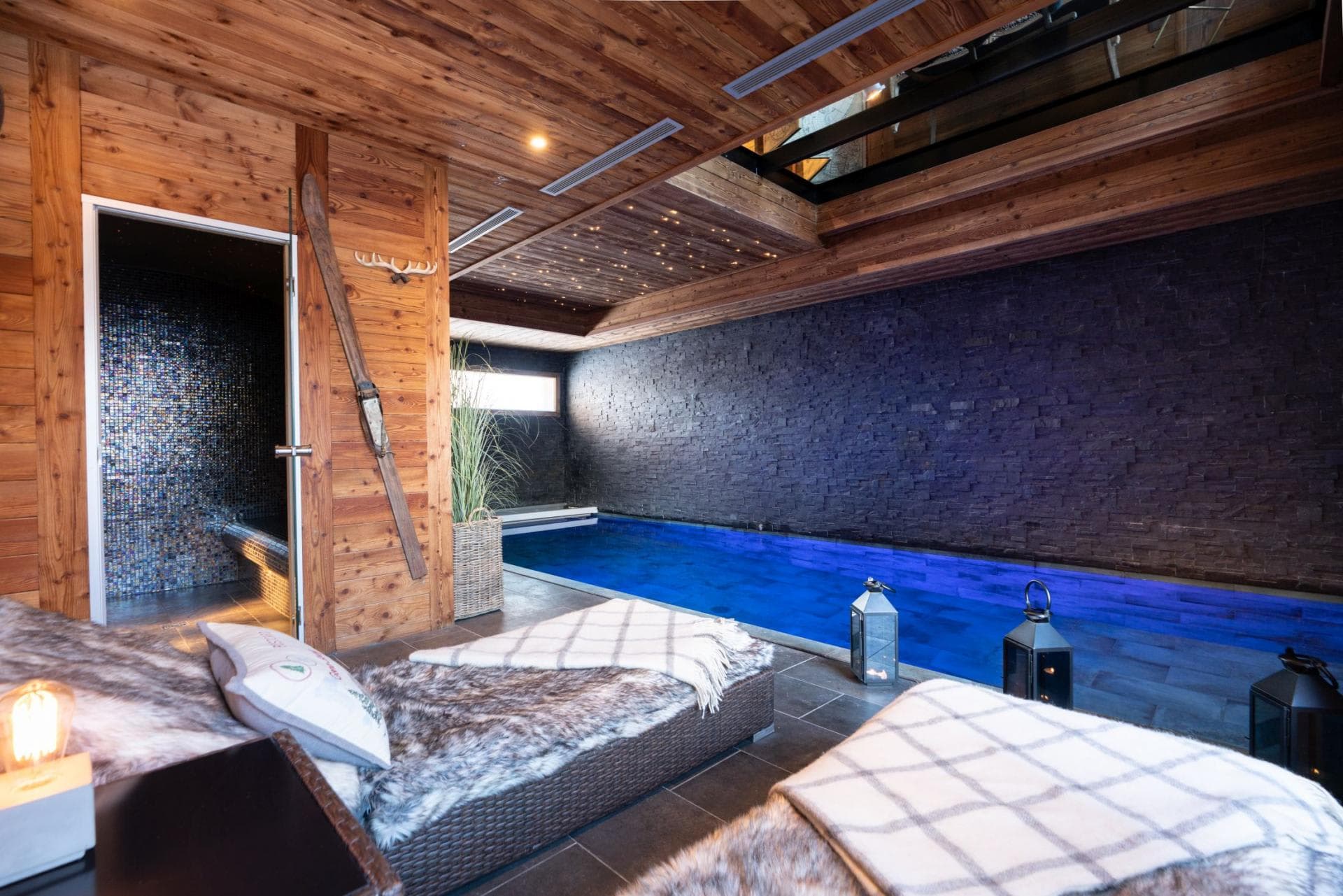 Indoor heated pool and steam room with poolside lounge seating
