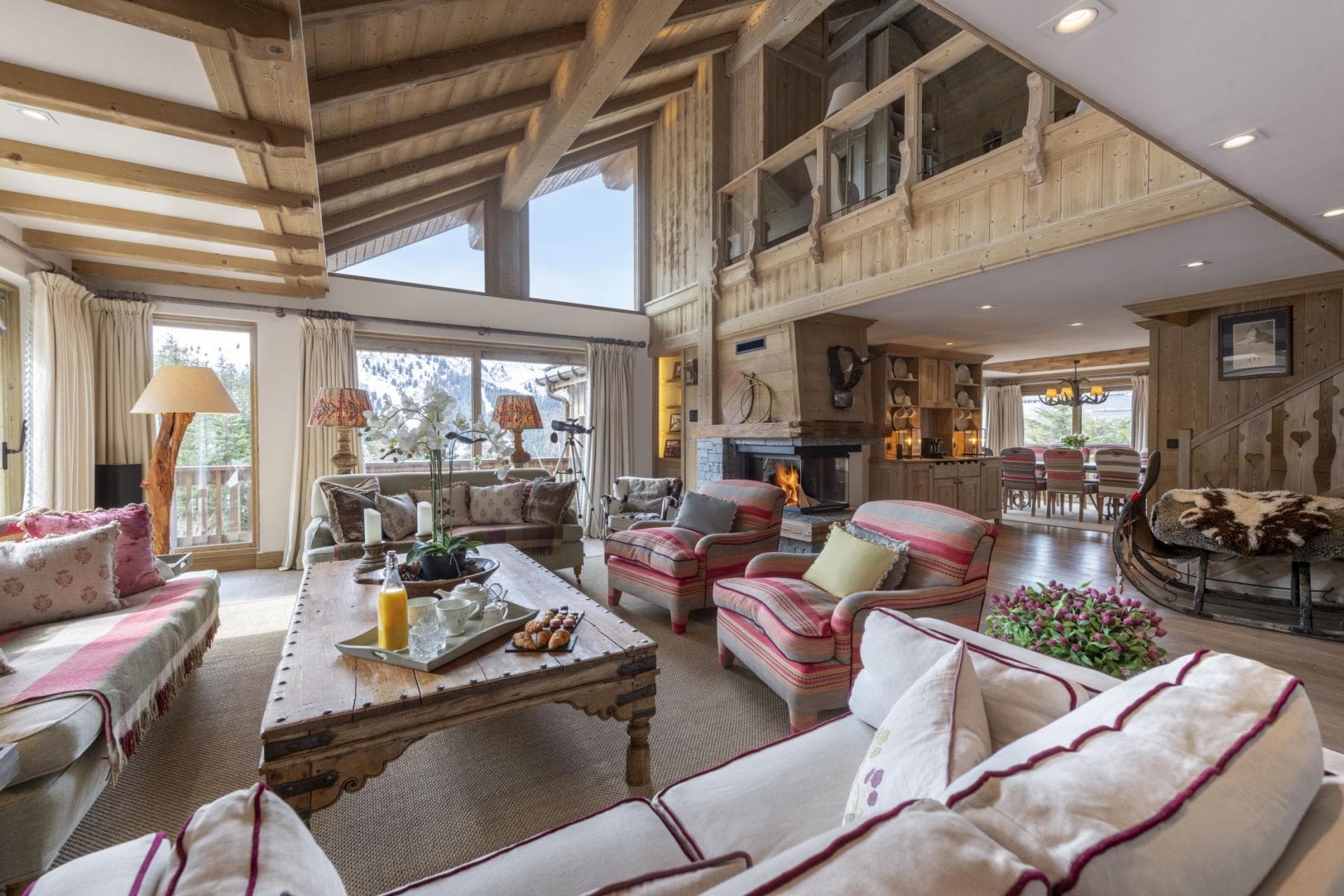 Open living area with wood-burning fireplace and mezzanine balcony above