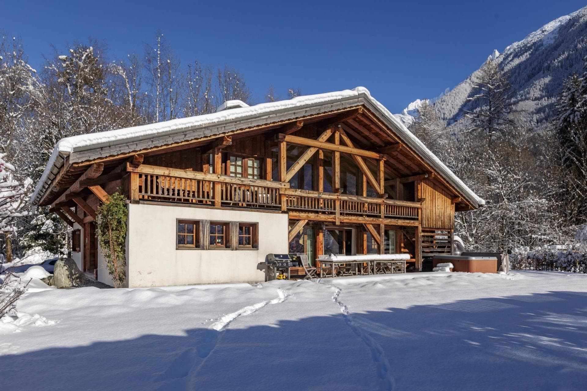 Chalet exterior with gas grill and private outdoor hot tub