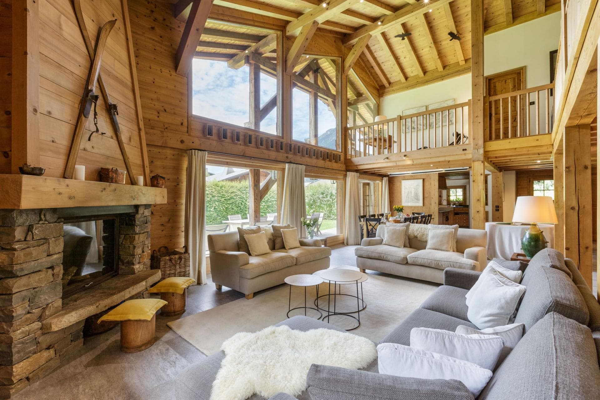 Double-height living room with stone fireplace and mezzanine level lounge