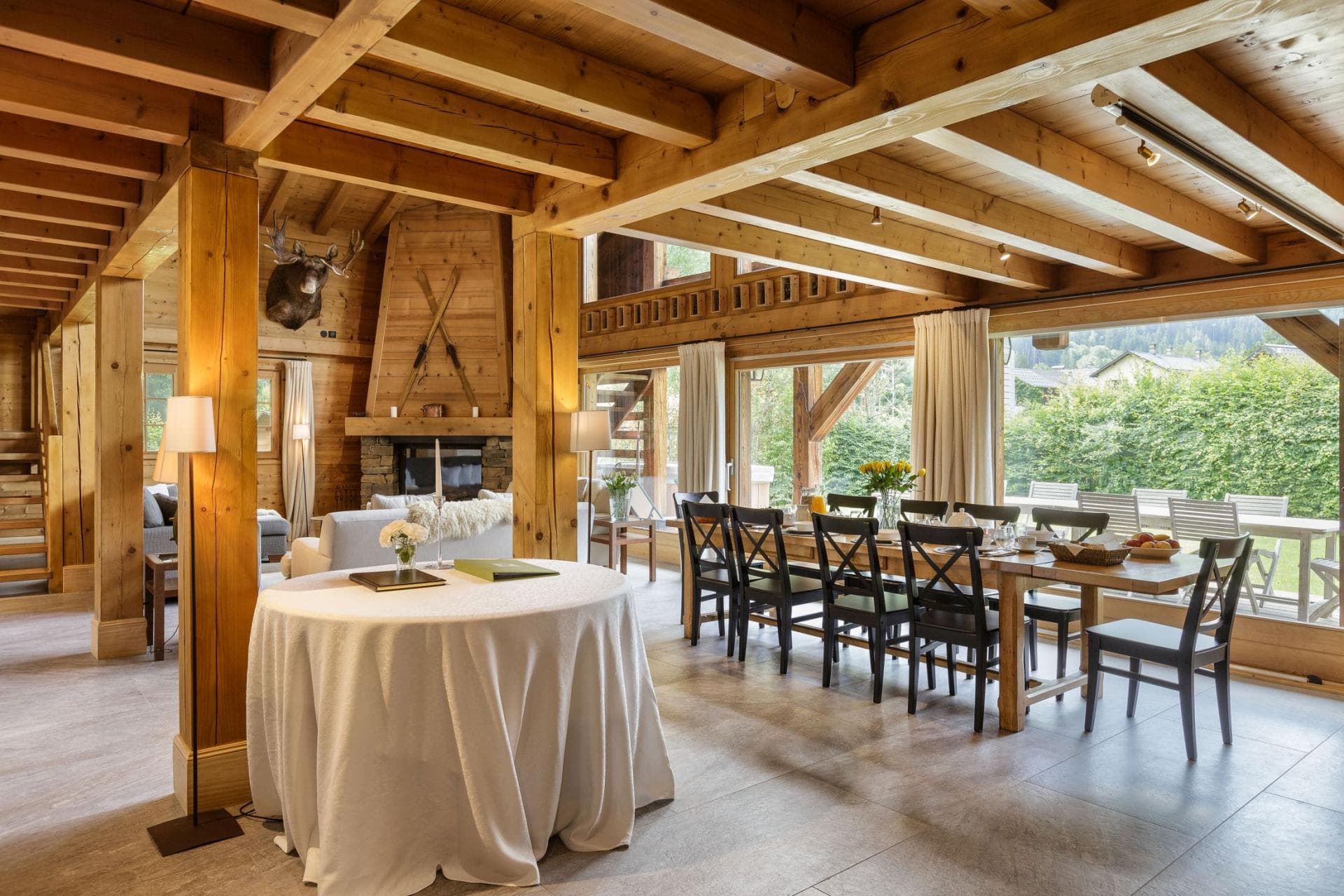 Open-plan dining area seating 10 with timber beams and garden access
