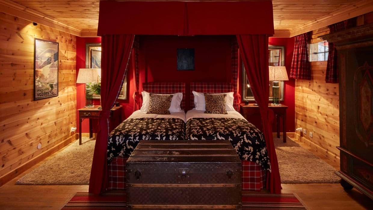 Guest bedroom with canopy-style twin beds and wood-paneled walls