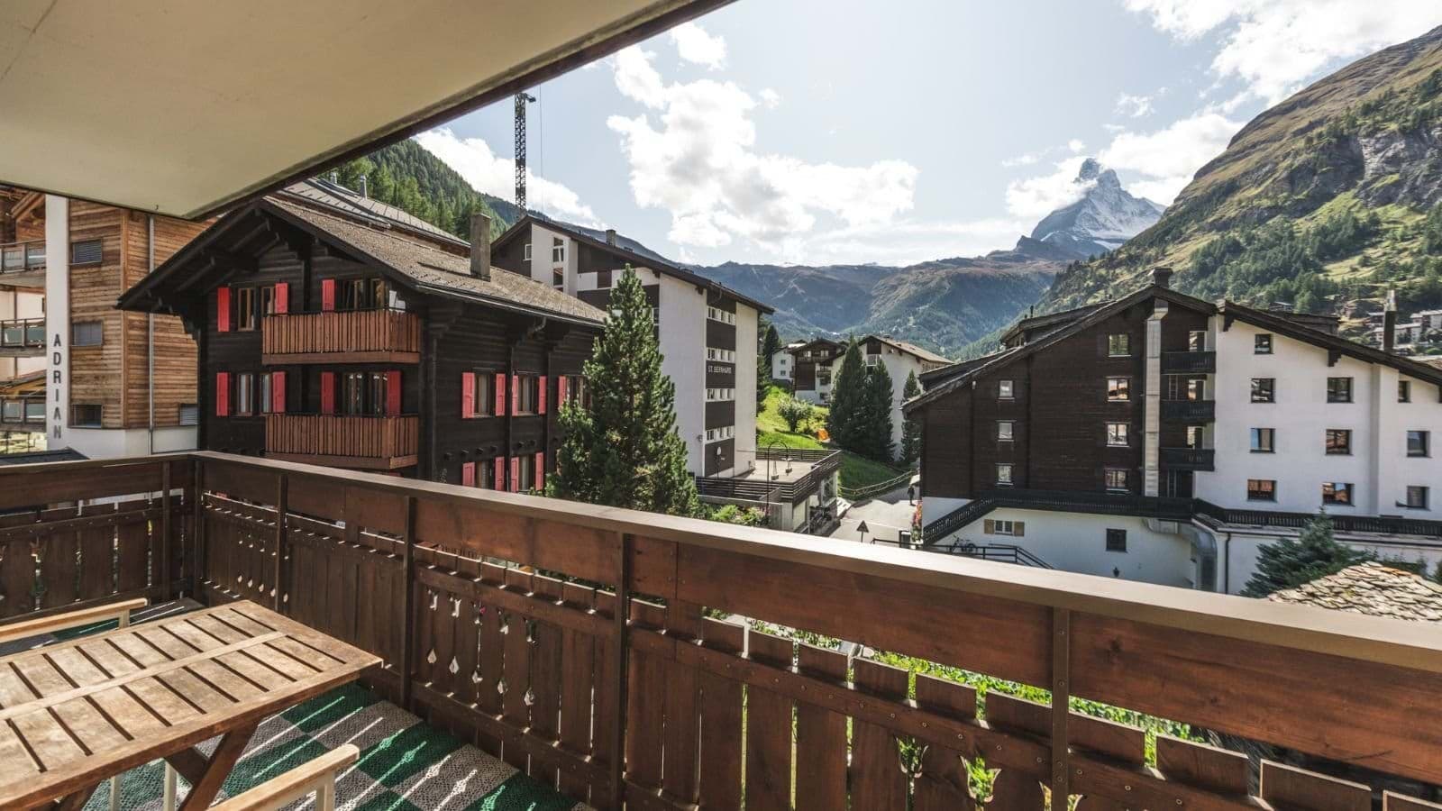 Private balcony with wooden dining table and Matterhorn views