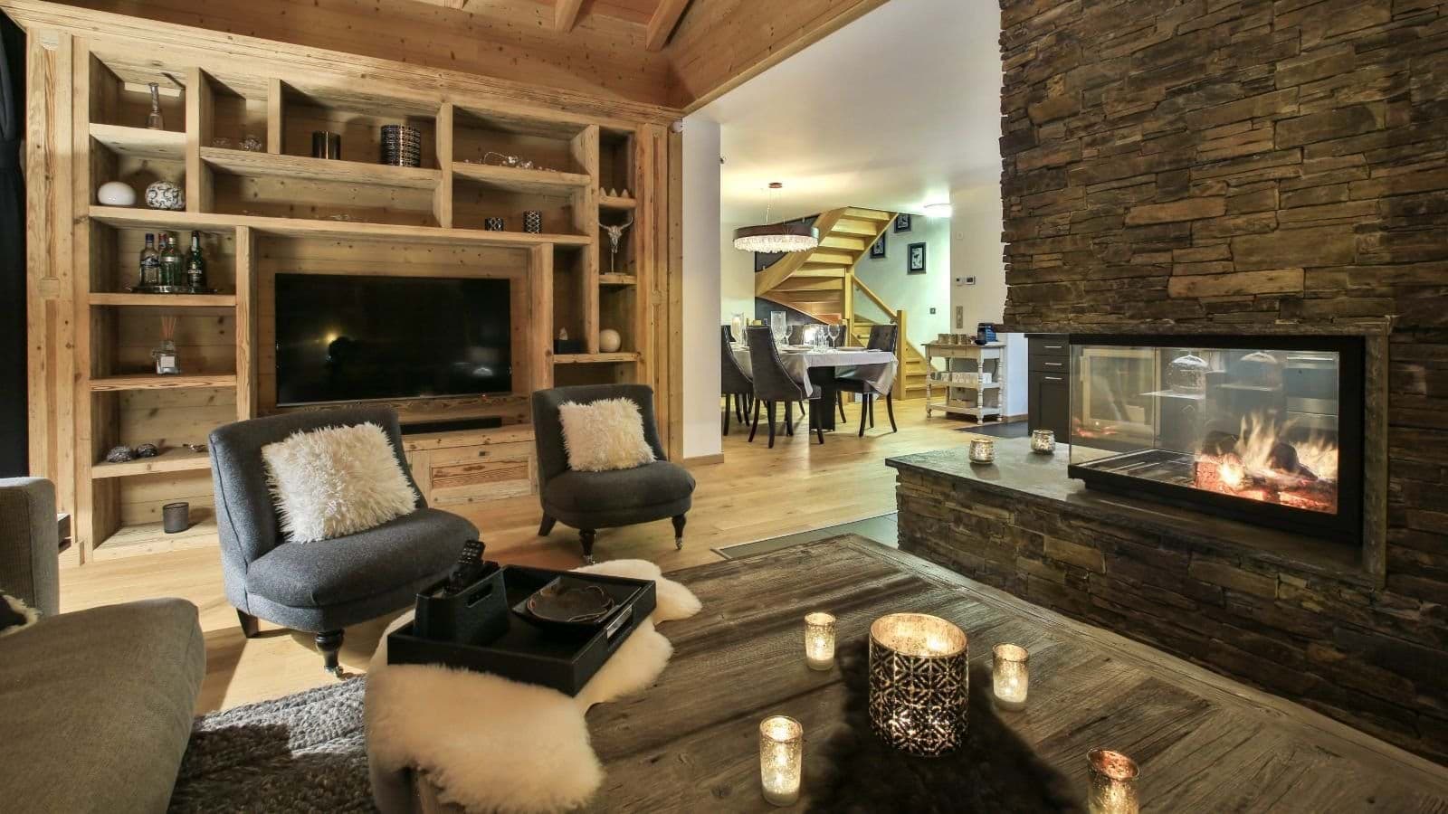 Living area with double-sided stone fireplace and custom wood built-ins