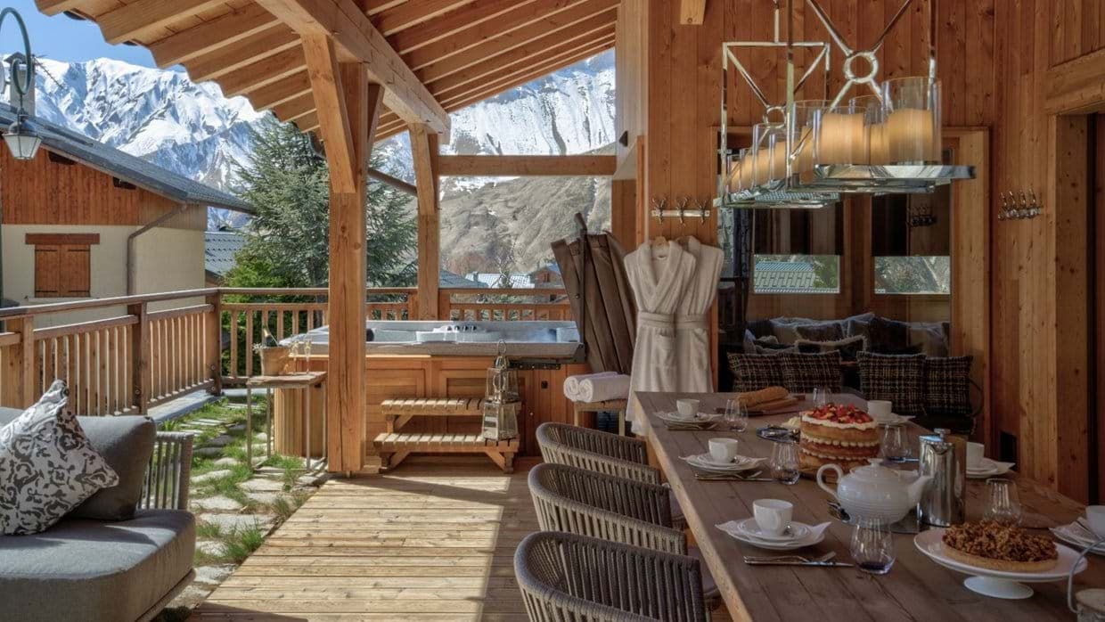 Covered terrace with hot tub and mountain views; seating for 8