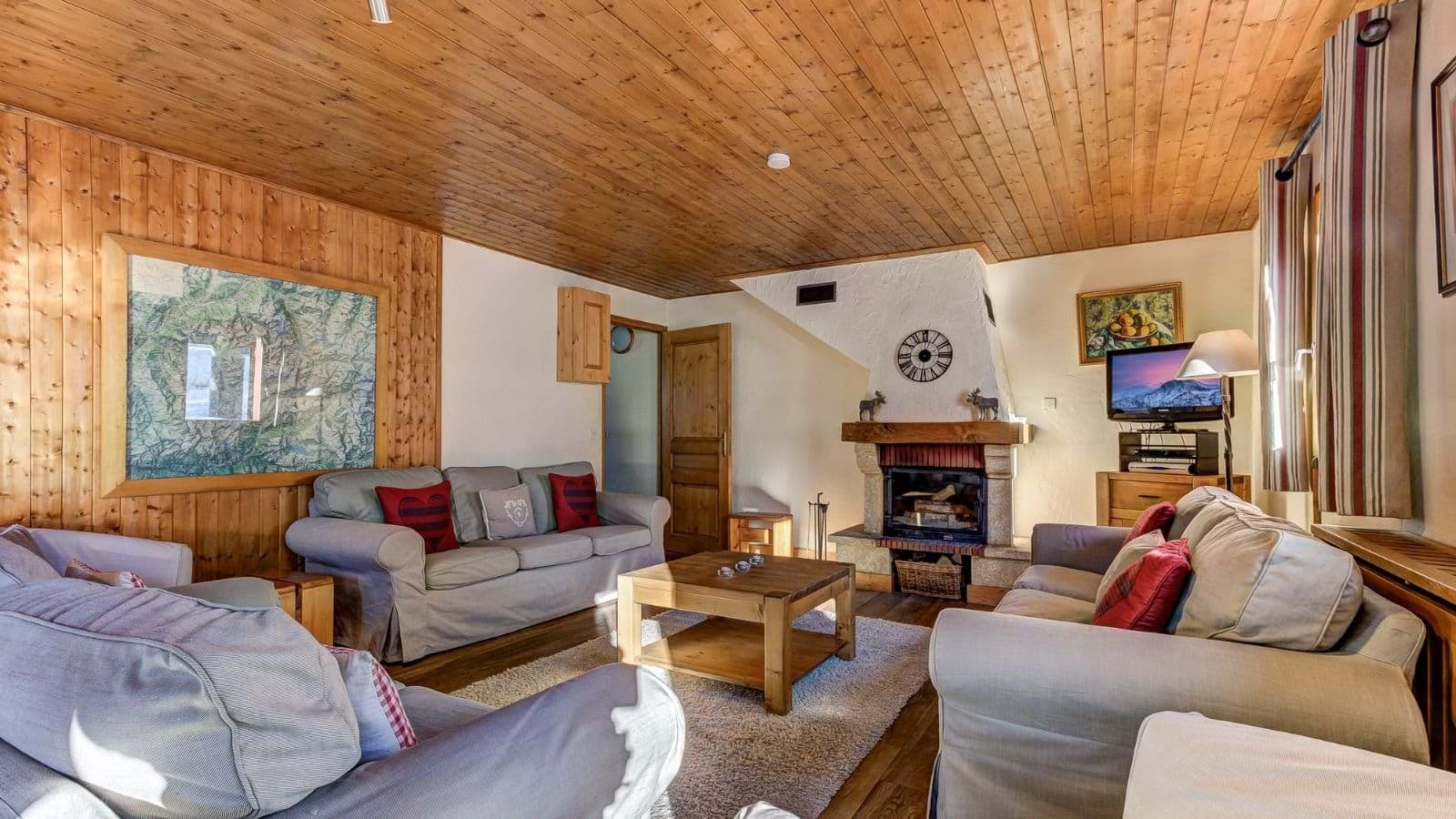 Living room with wood-beamed ceiling, fireplace, and seating for 8+