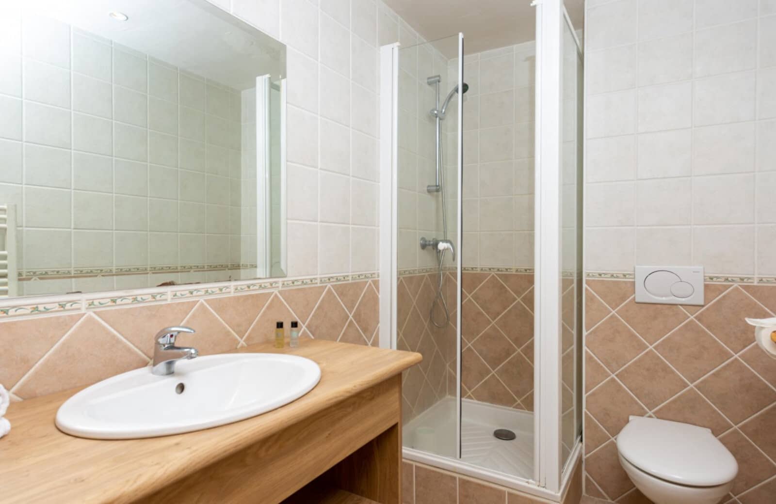 Bathroom with walk-in shower and wood-topped vanity