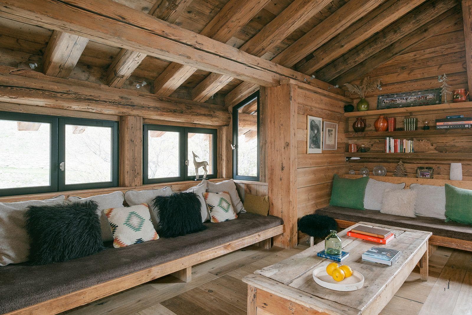 Log cabin living room with built-in bench seating and library shelving
