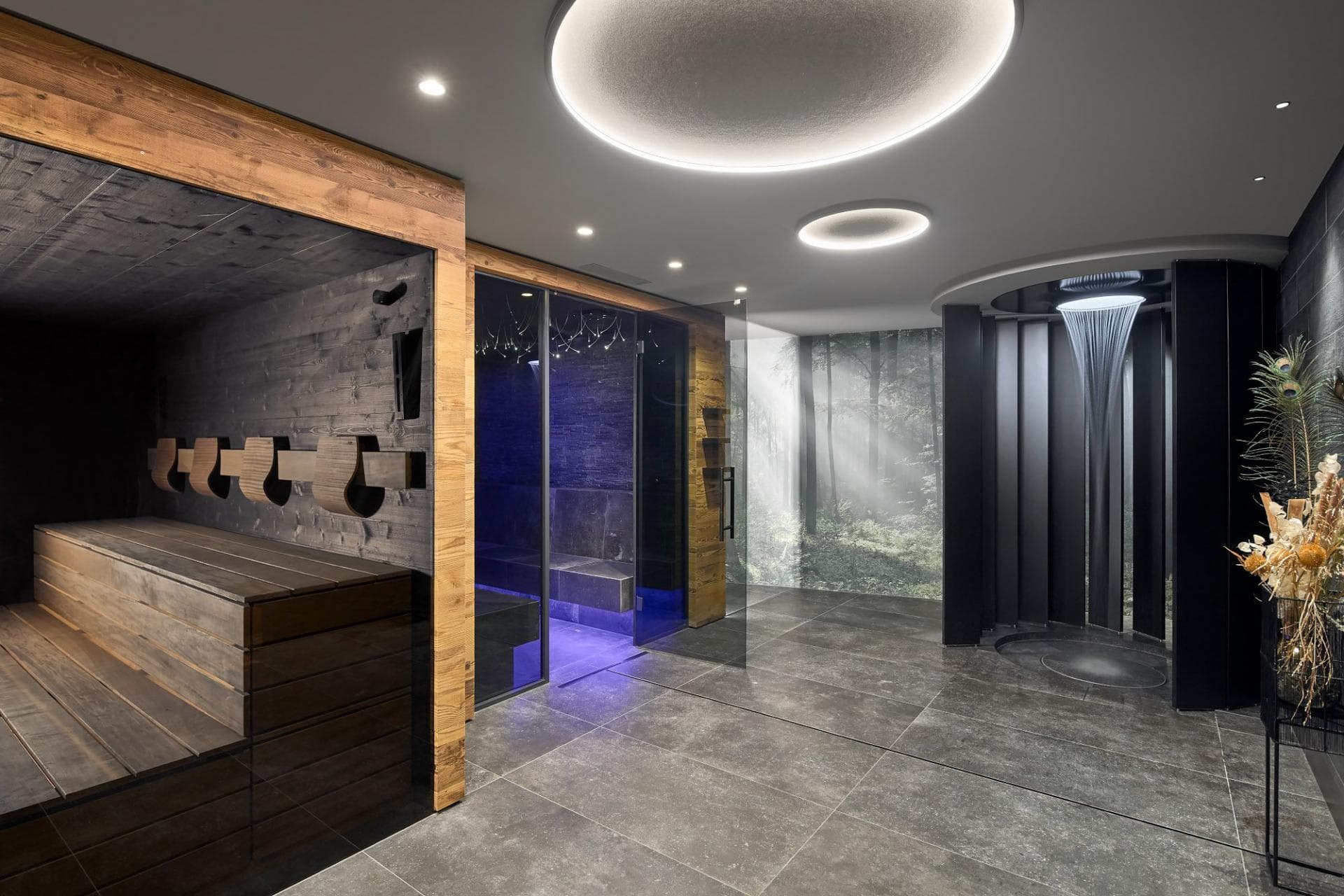 Spa area featuring tiered wood sauna, steam room, and rainfall shower