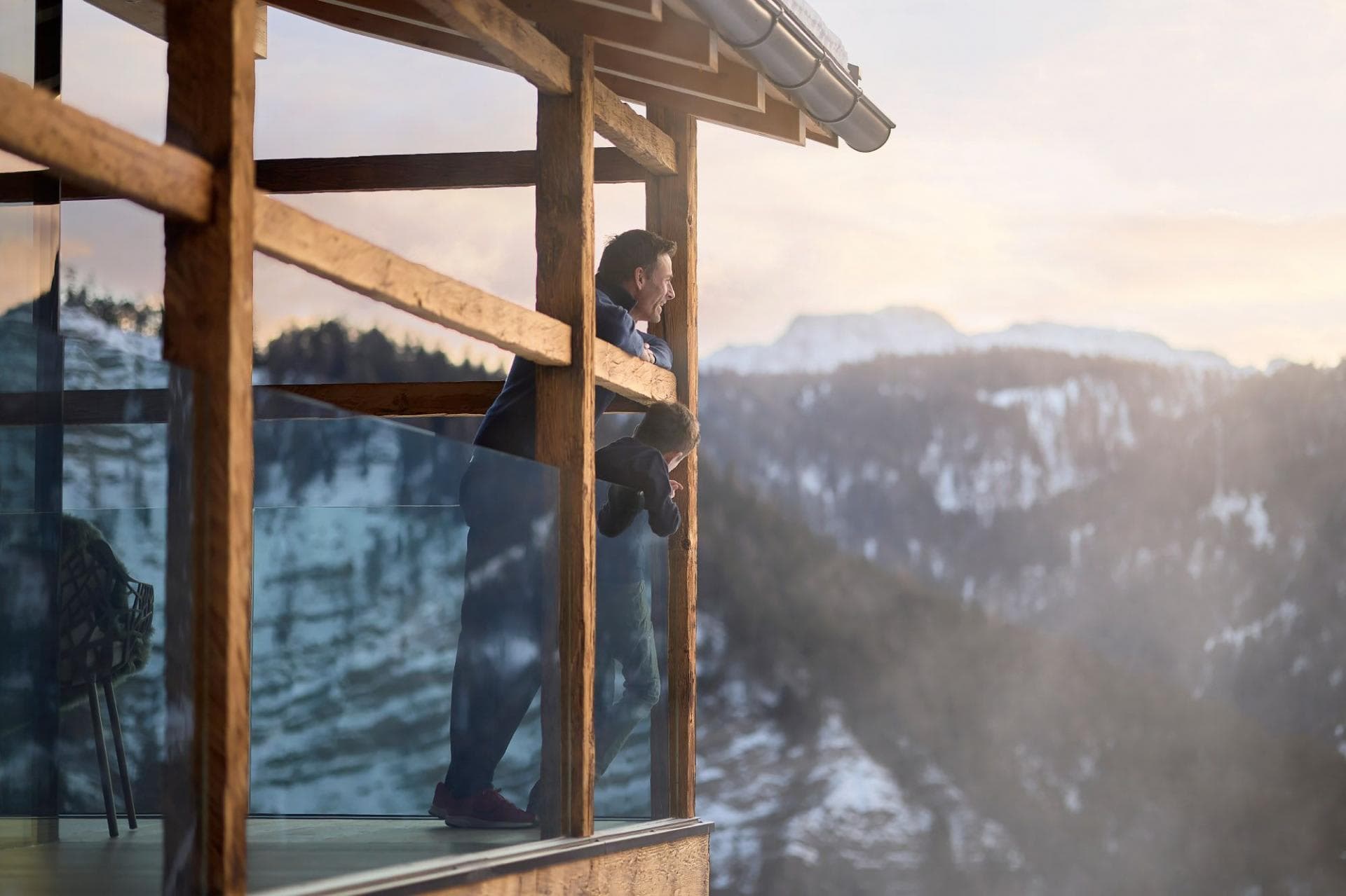 Covered timber balcony with glass railings and mountain views