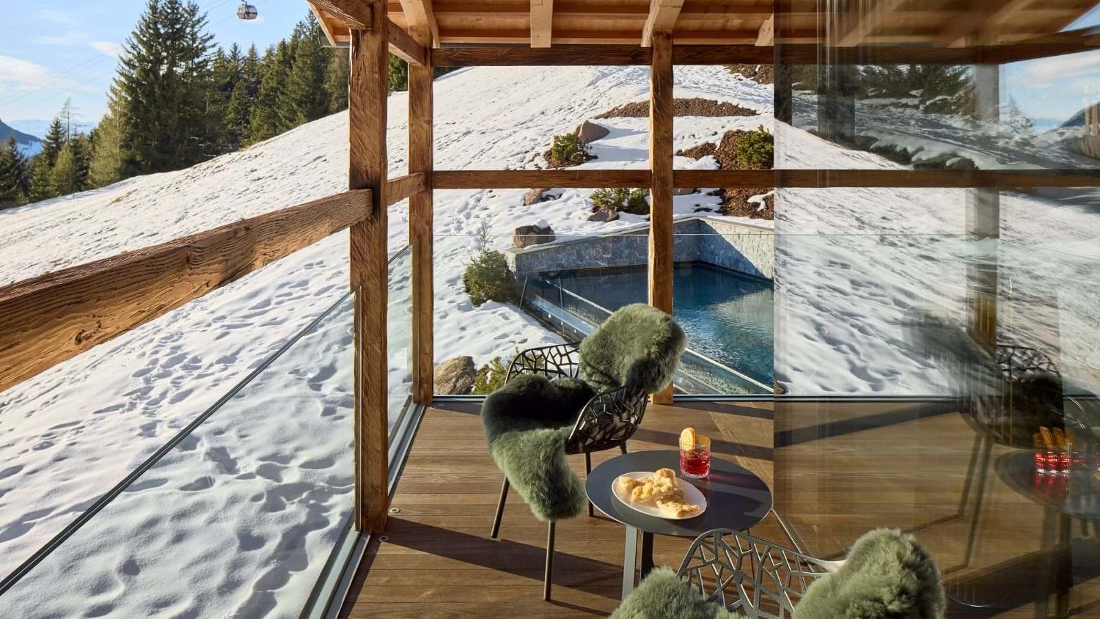 Covered balcony overlooks ski slopes and heated outdoor pool
