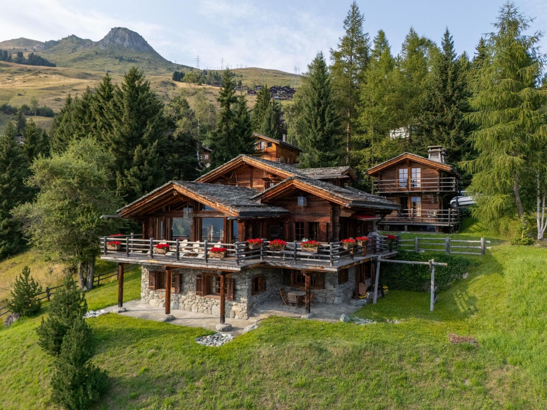 Chalet exterior with wrap-around balcony and lower stone terrace