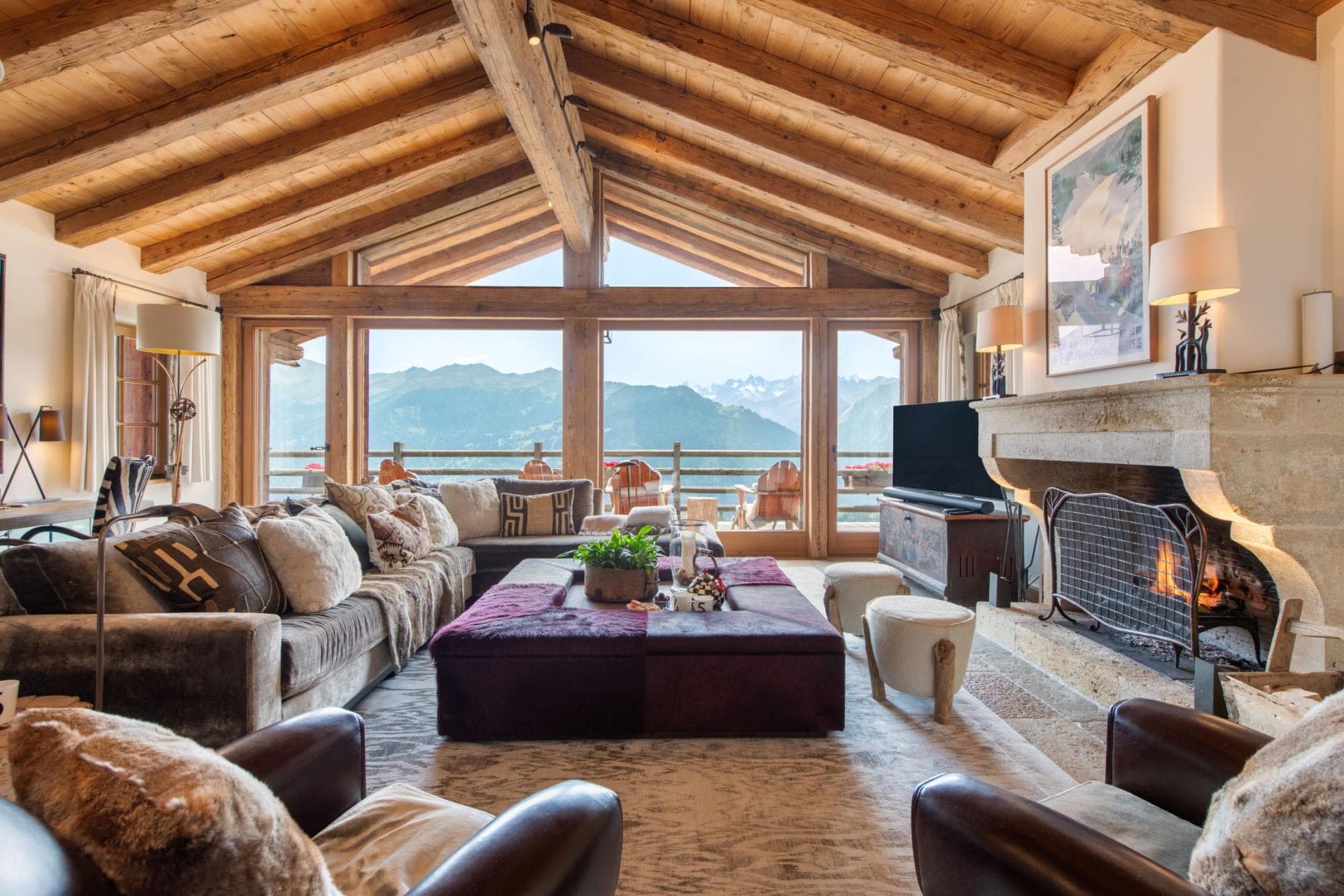 Living area with wood-burning fireplace and floor-to-ceiling mountain views