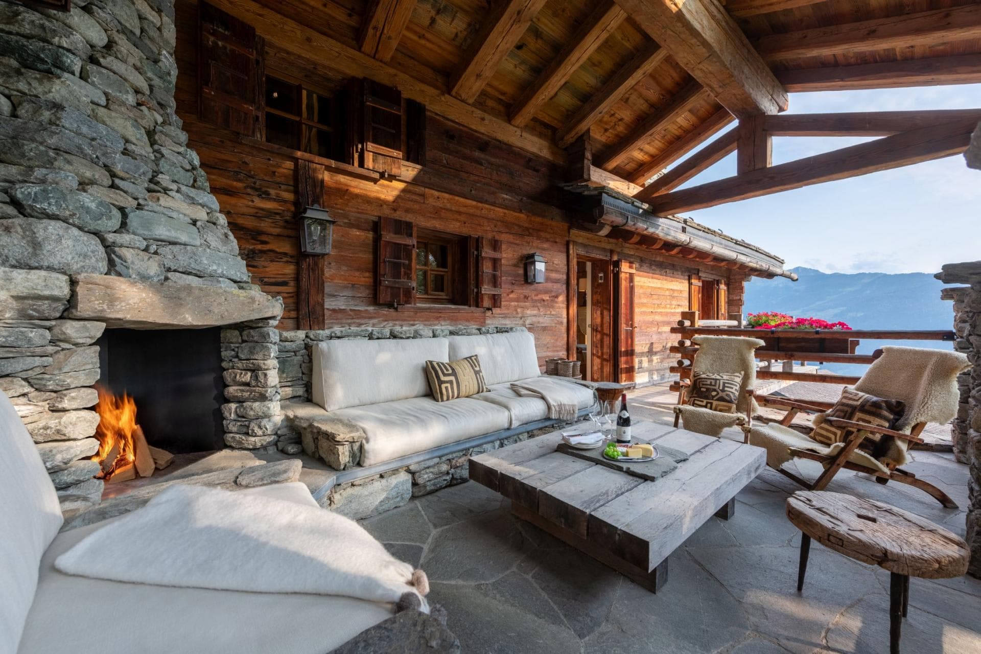 Covered stone terrace with wood-burning fireplace and mountain views