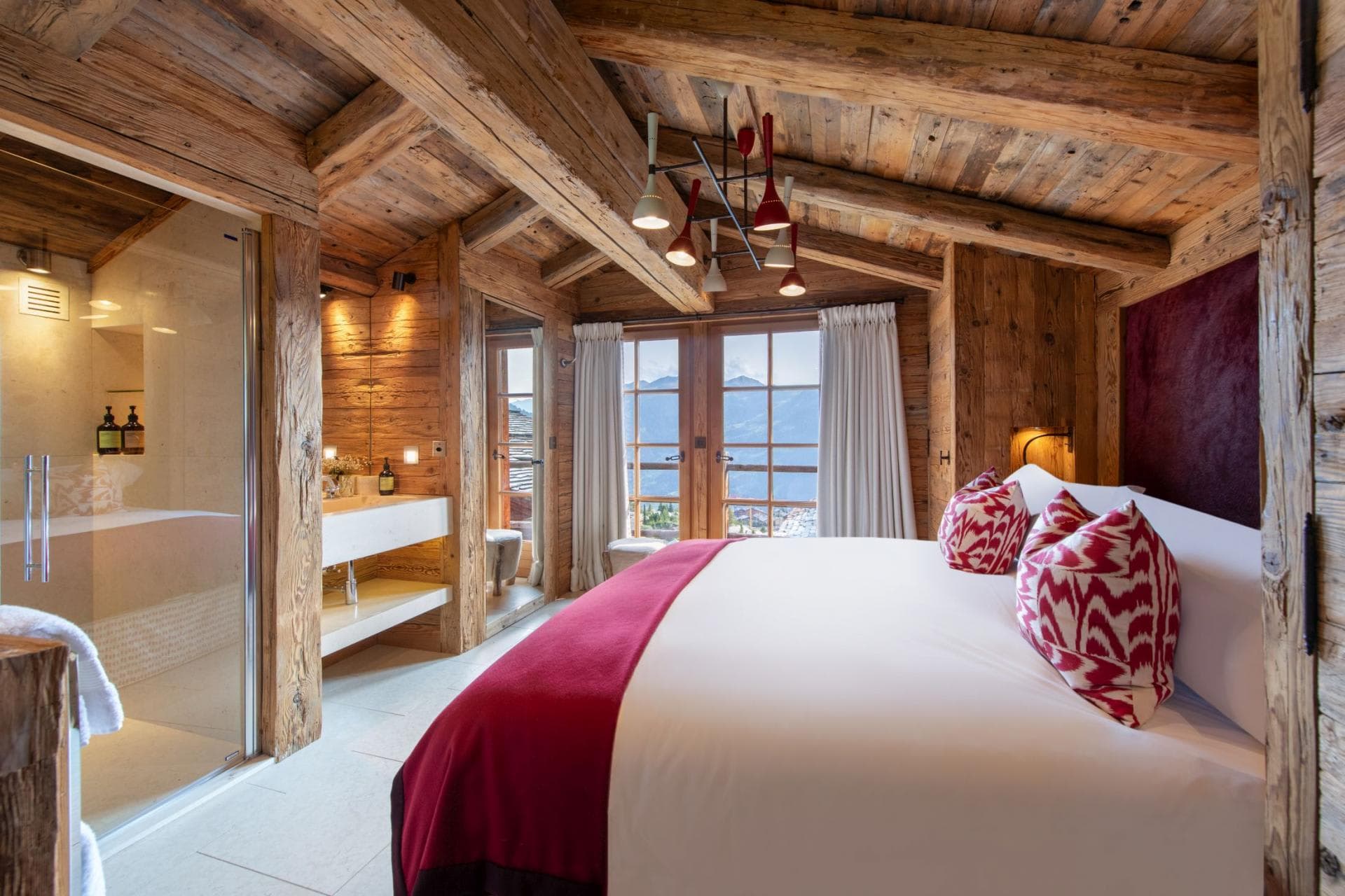 Primary bedroom with ensuite bathroom, king bed, and mountain-view balcony