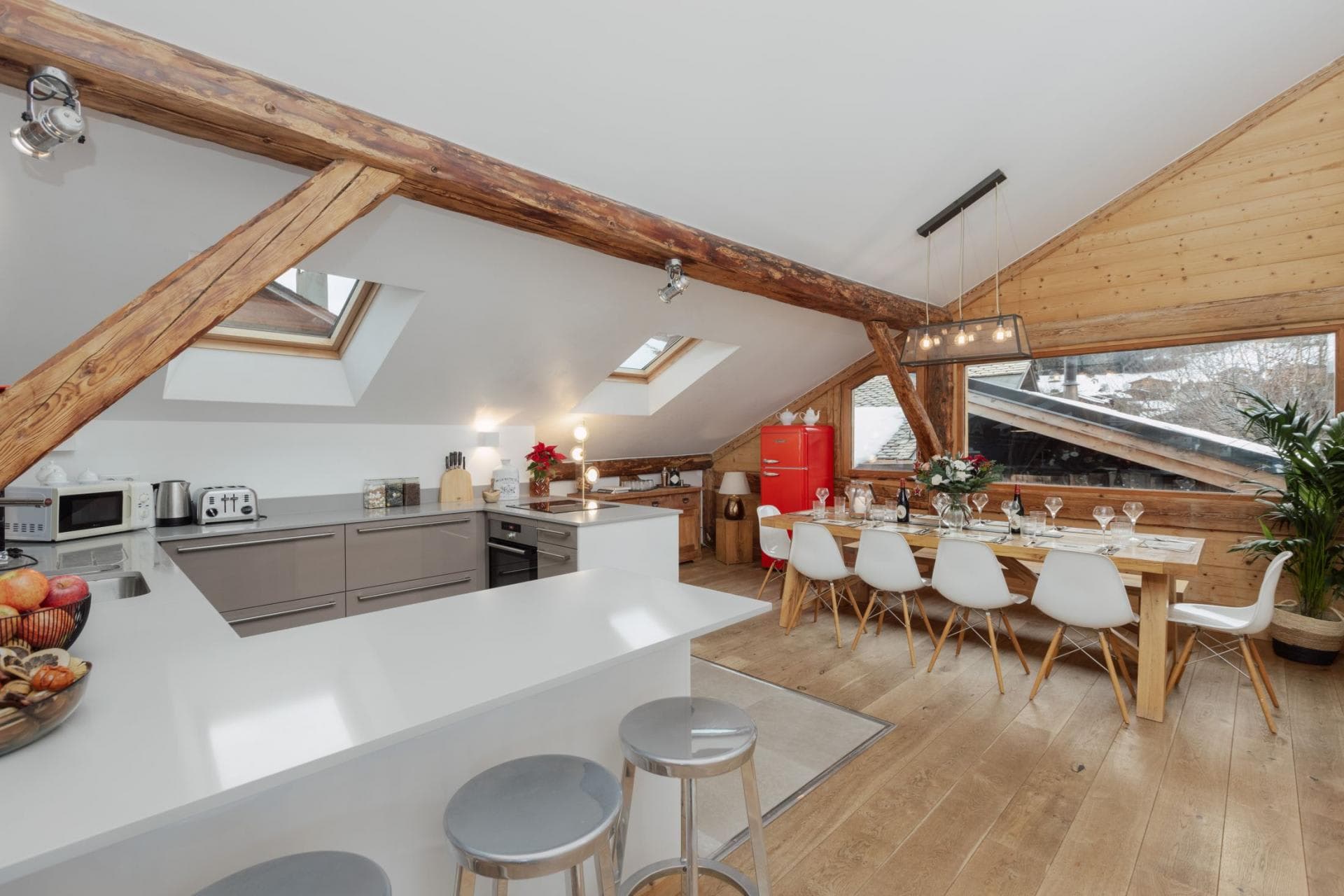 Open-plan kitchen and dining area with original timber beams; seating for 10