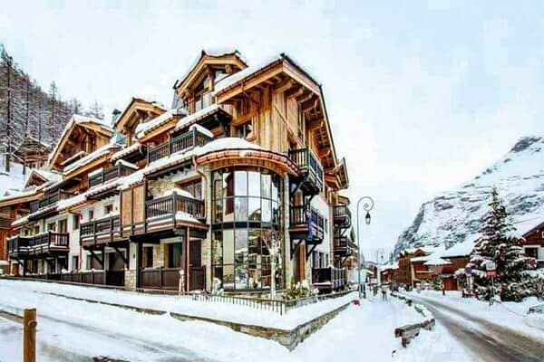 Ski-in chalet exterior featuring private balconies and floor-to-ceiling windows
