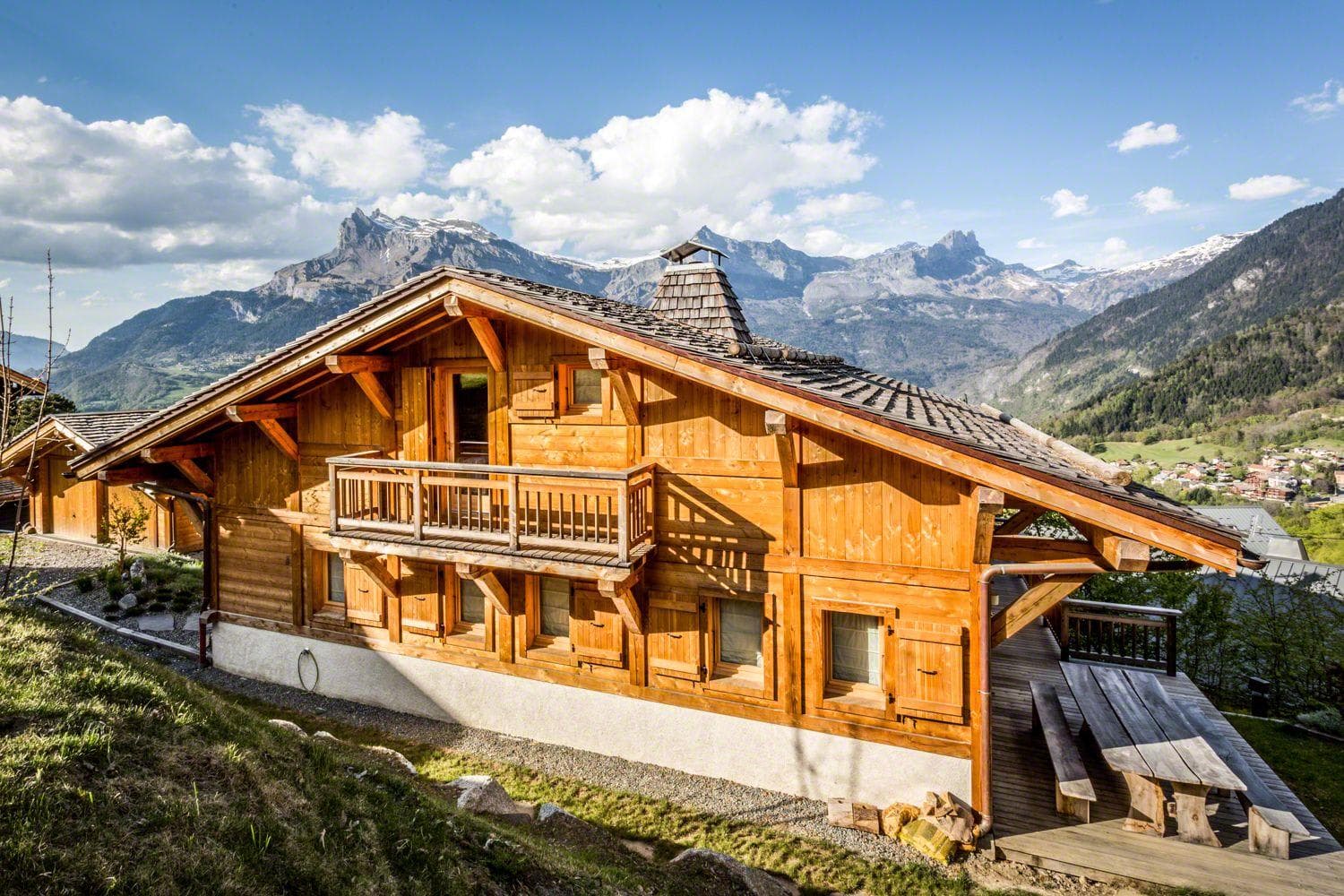 Alpine chalet exterior with mountain views; direct valley vista from hillside location