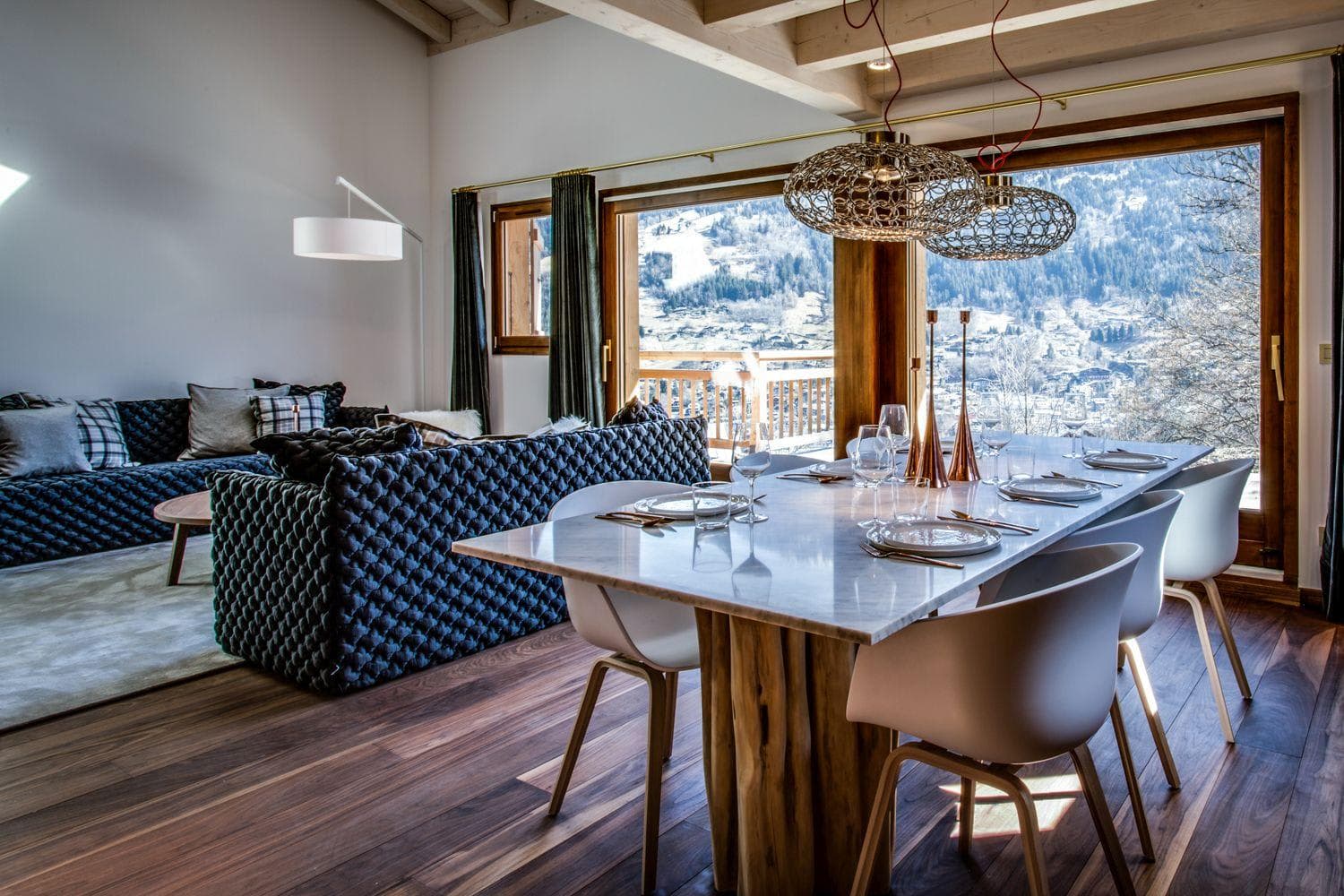 Dining area seats 8; floor-to-ceiling windows frame snowy mountain valley views